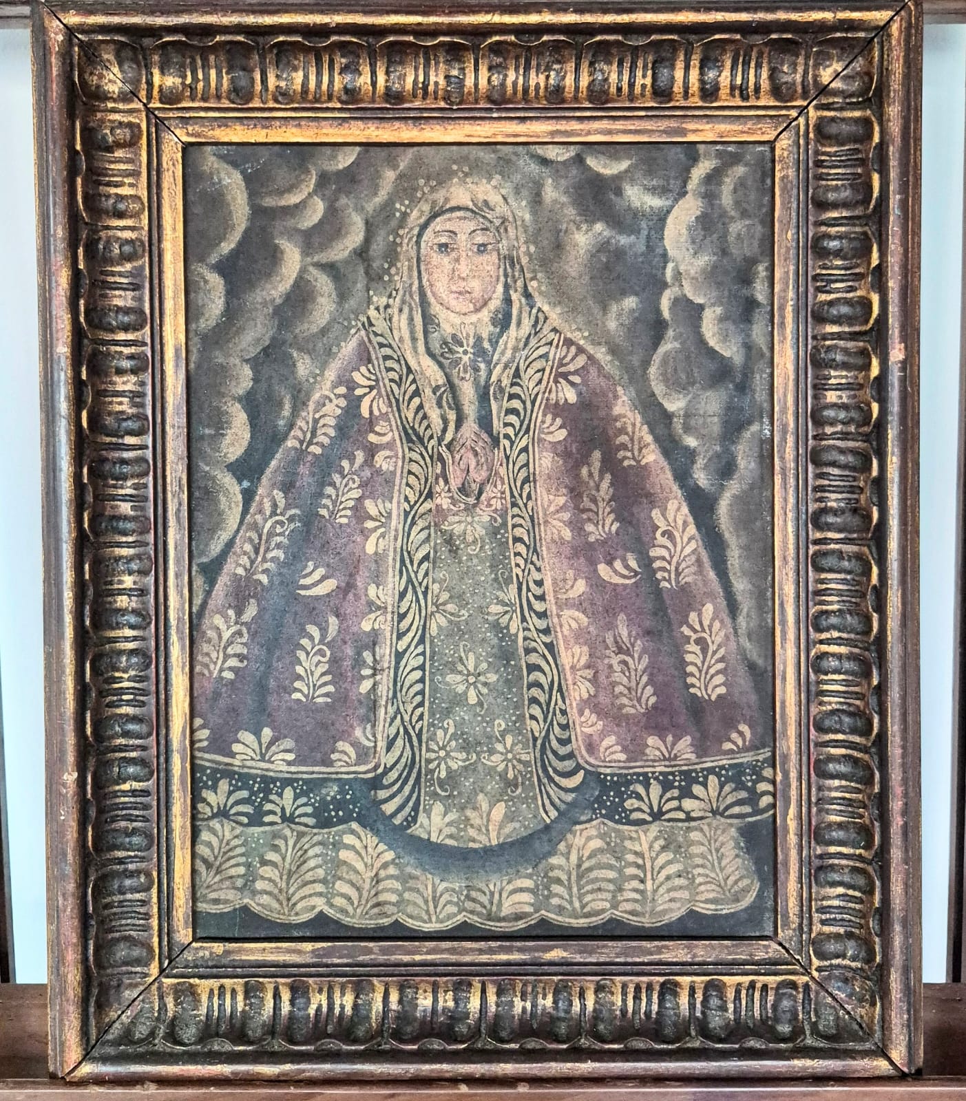  Quadro com pintura,  óleo sobre tela,  sacra antiga de Nossa Senhora, de Escola Cusquenha, caracterizada por traços coloniais, mantos ricamente ornamentados.