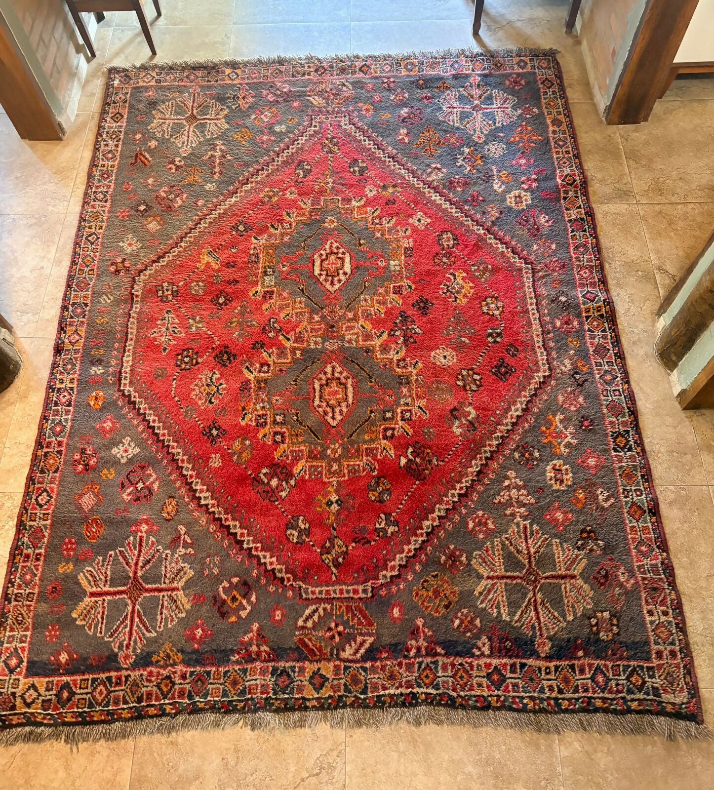 Tapete persa com medalhão central geométrico em vermelho intenso