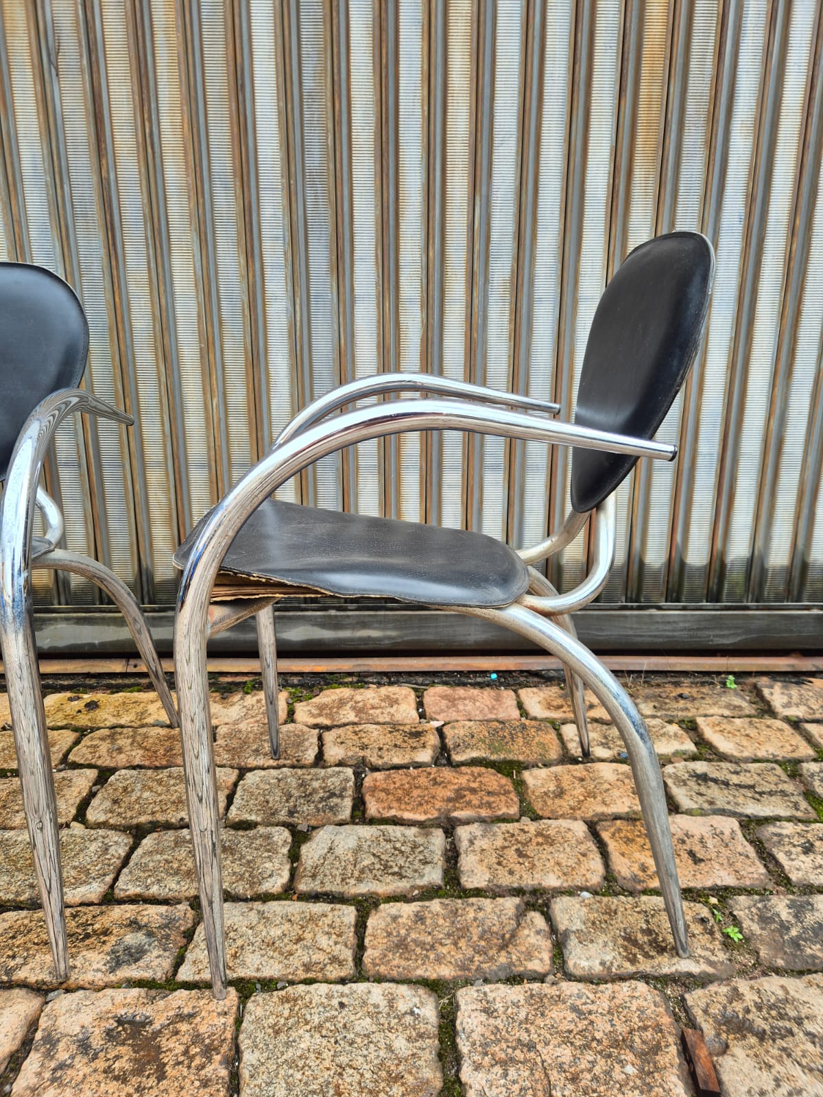 Cadeiras de Design Italiano com linhas curvas em metal tubular e assento preto 
