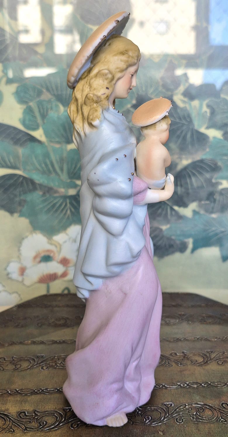 Estatueta em porcelana estadounidense não marcada de Nossa Senhora com o menino Jesus nos braços.