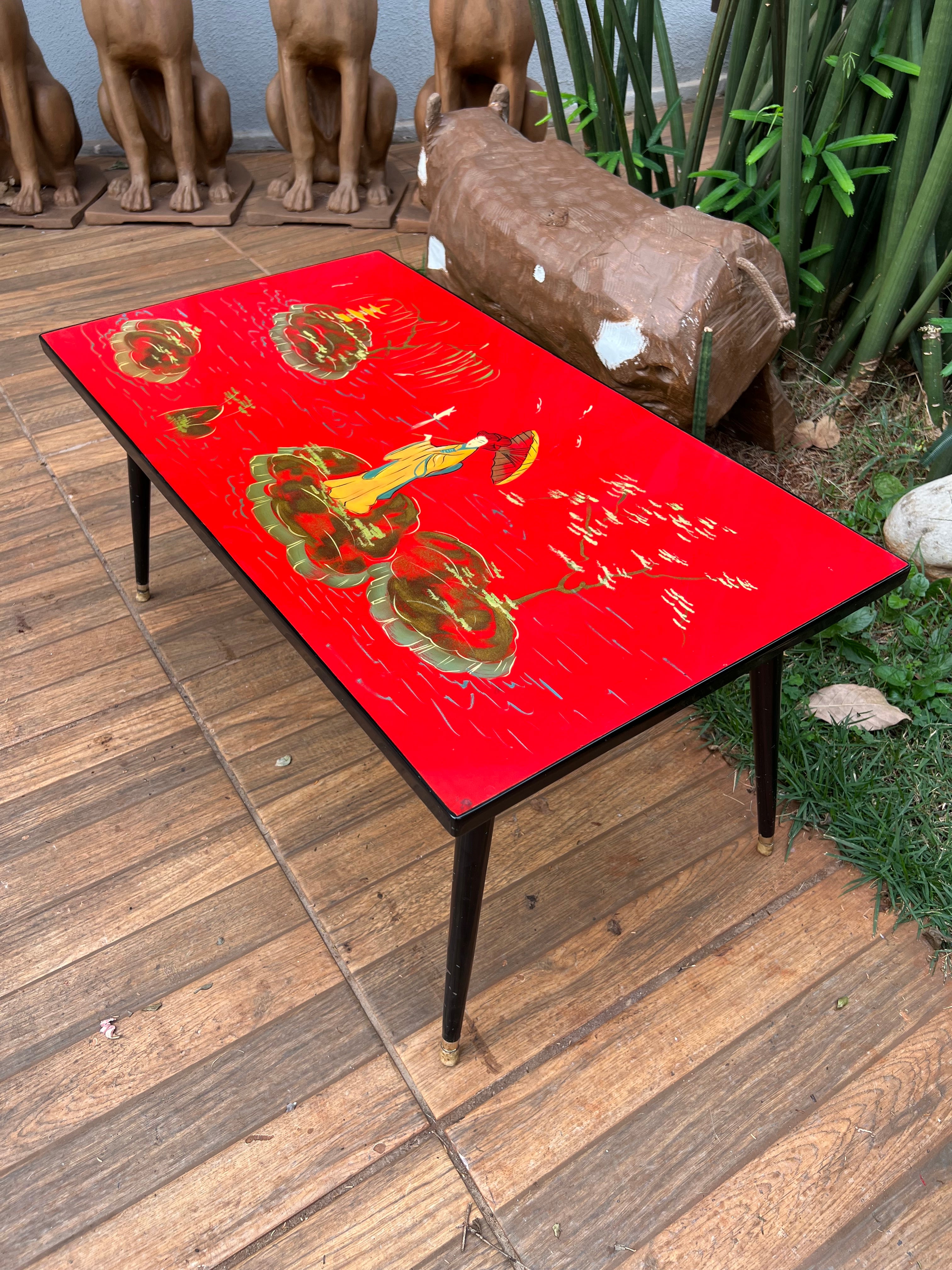 Mesa de centro retangular oriental com pés palito e tampo vermelho 