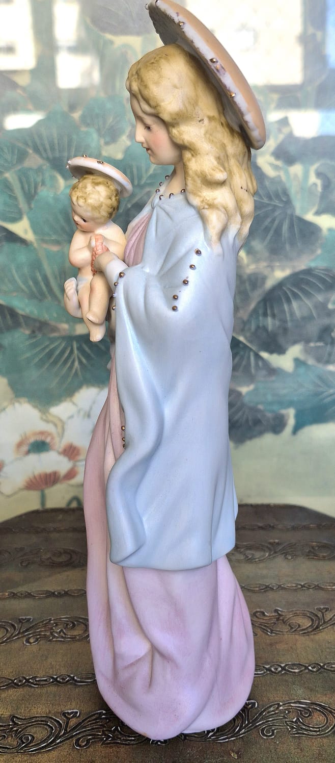 Estatueta em porcelana estadounidense não marcada de Nossa Senhora com o menino Jesus nos braços.