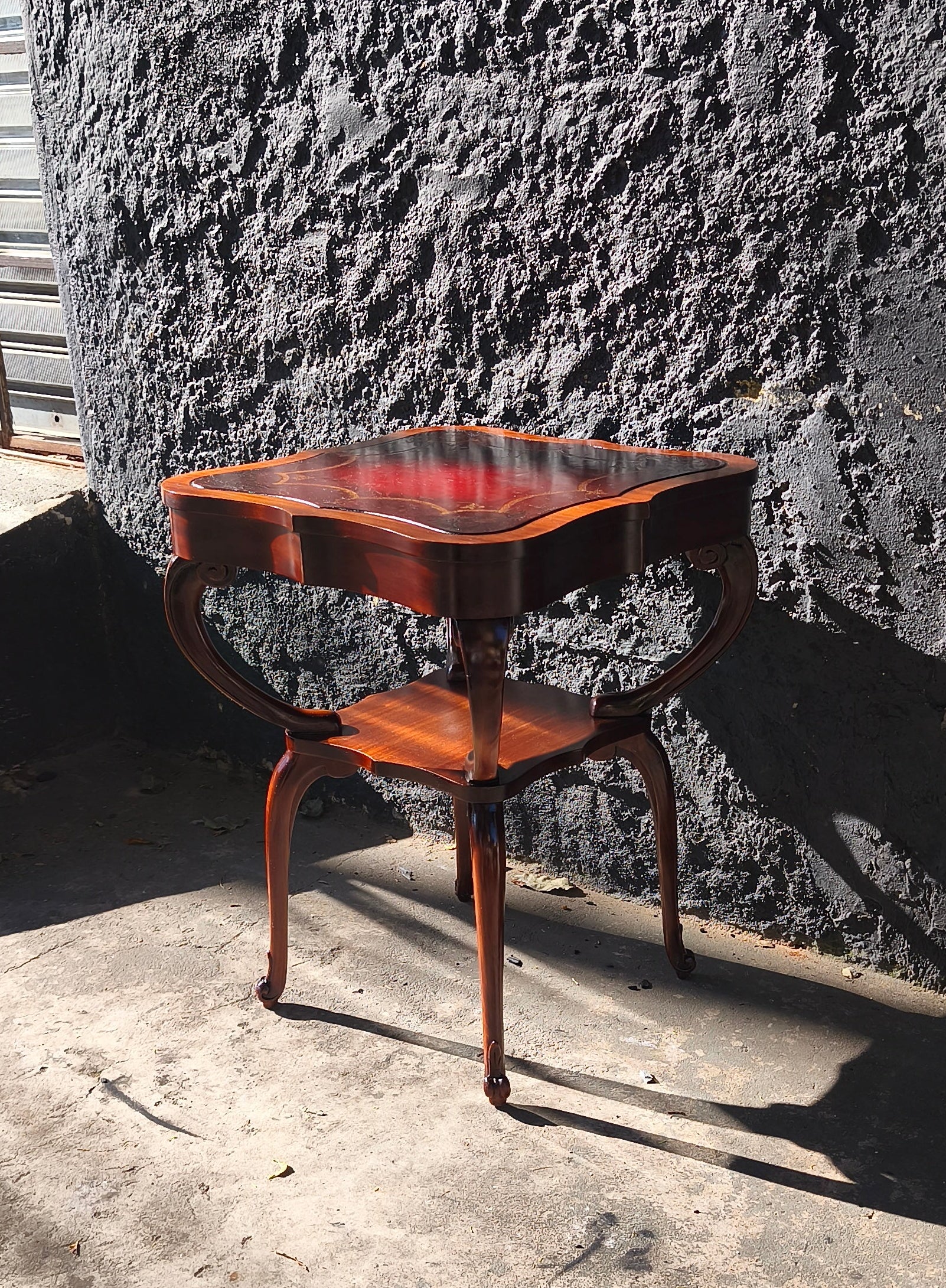 Mesa auxiliar quadrada com tampo em couro vermelho com detalhes florais e pernas torneadas