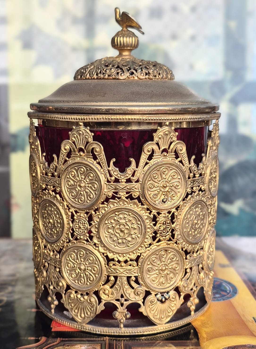  Potiche vintage com parte interna em vidro cranberry e parte externa em metal trabalhado em filigrana e ornamentado com medalhões, como antigas rendas metálicas.