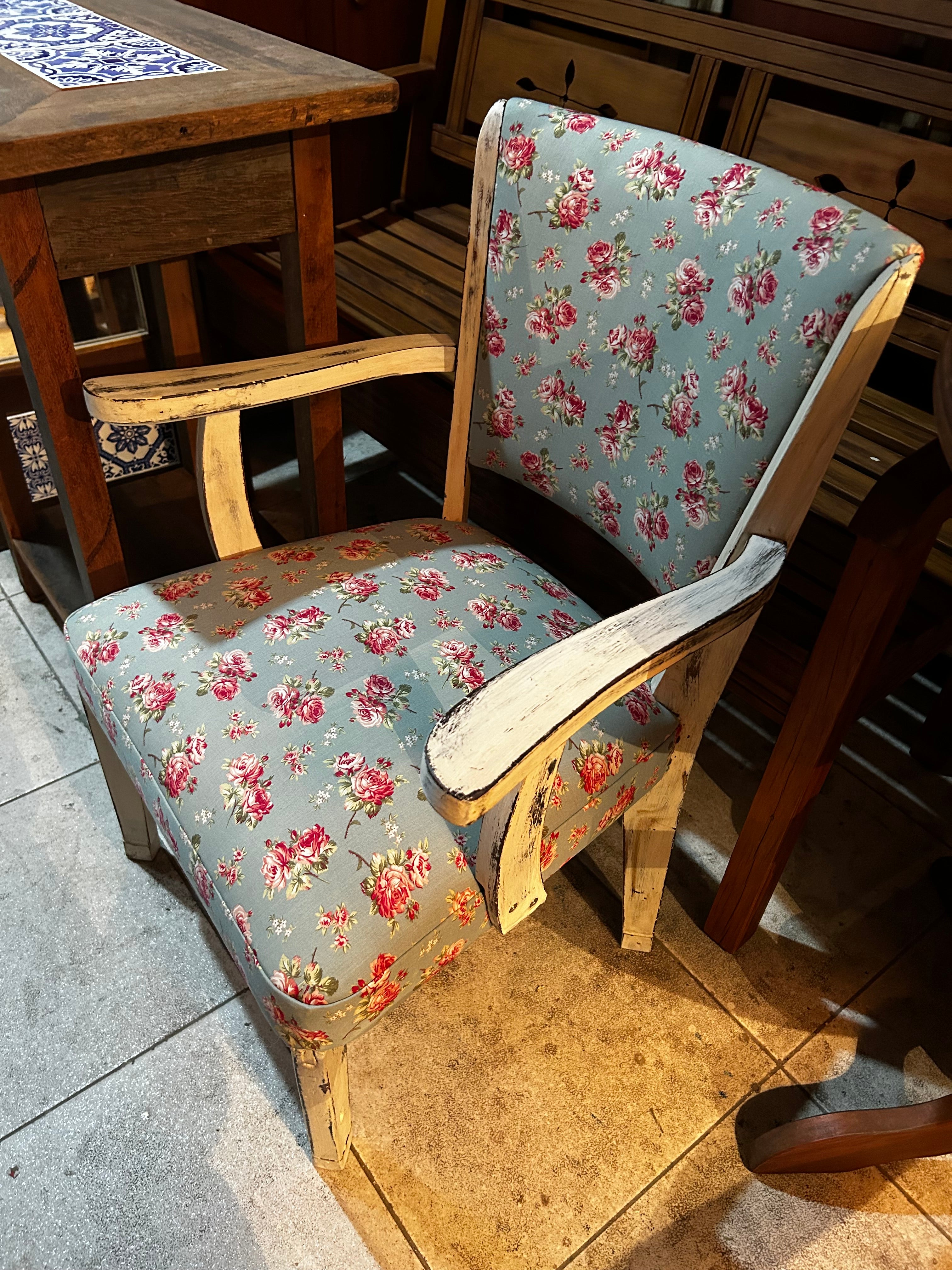 Cadeira antiga com braço e estofado azul com flores 