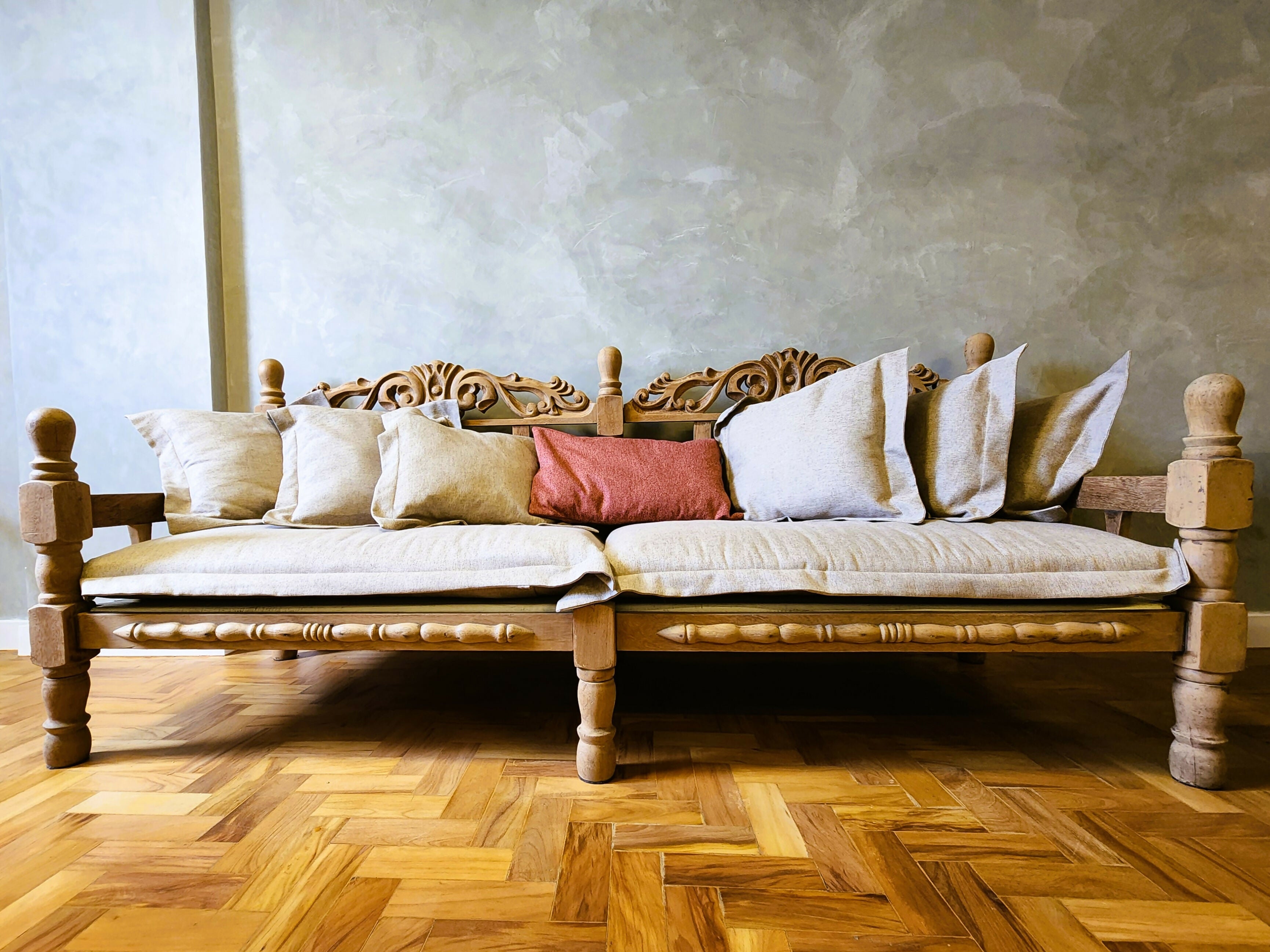Sofá de madeira maciça entalhada com almofadas soltas