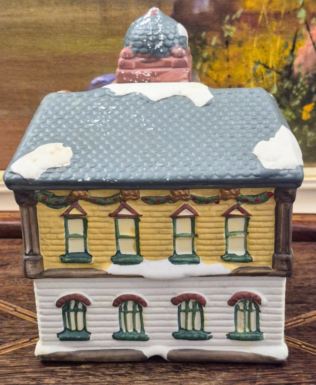 Casinha luminária representando estação de trem vintage, feita em biscuit, com portas, janelas e relógio frontal vazados para iluminação interna.