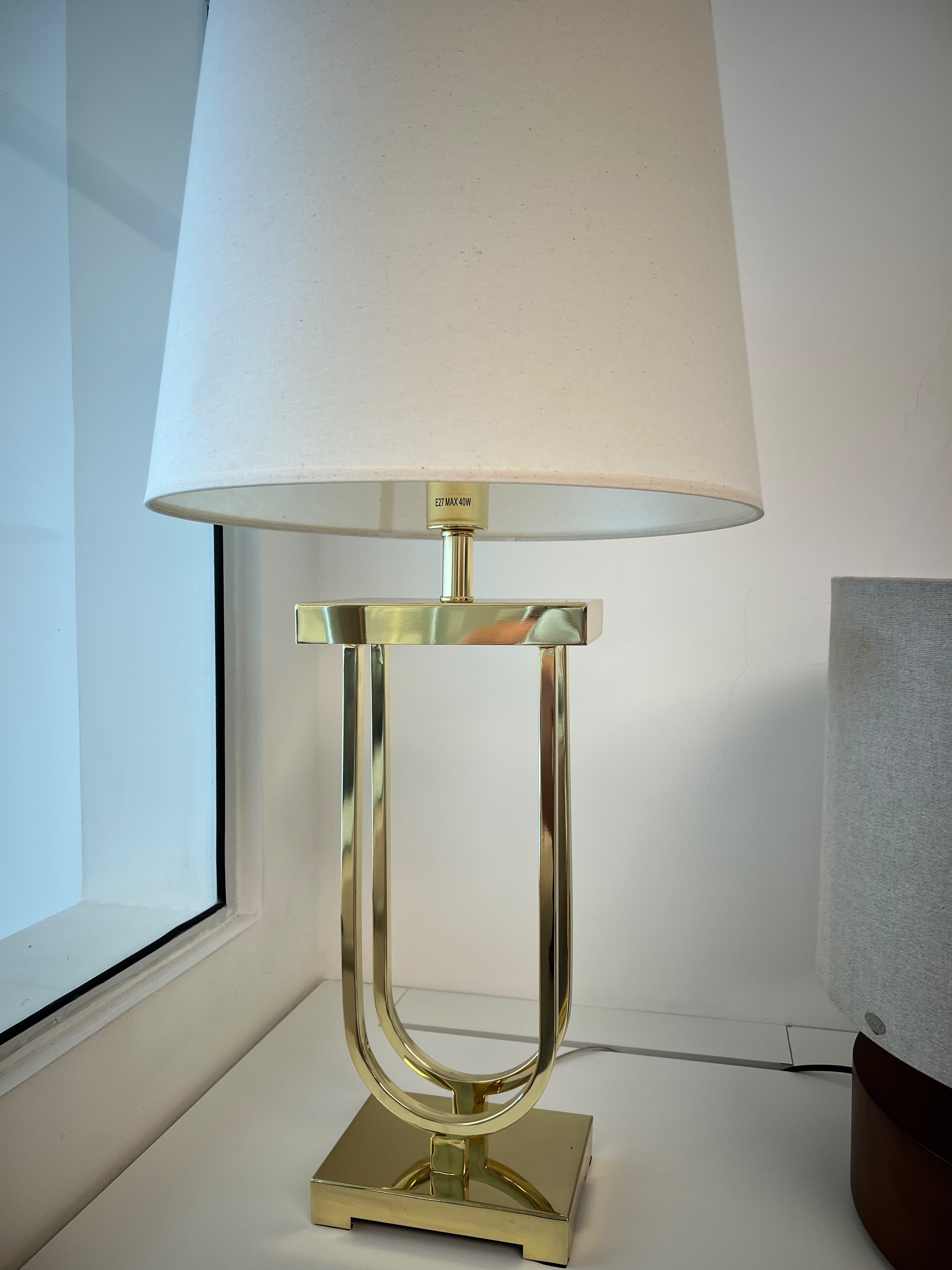 ABAJUR BELA ILUMINAÇÃO, COM CÚPULA EM TECIDO CLARO E BASE DOURADA