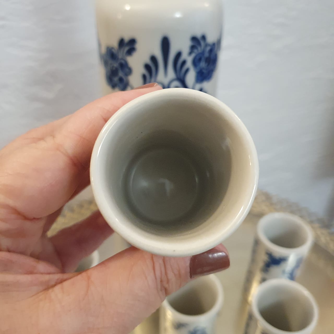 Garrafa licoreira com 6 copinhos em porcelana Ceramarte azul e branco com pintura holandesa, modelo: holandês. 
