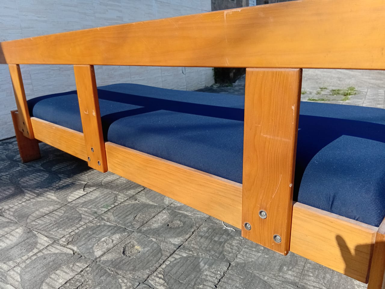 Sofá de madeira com estofado azul 