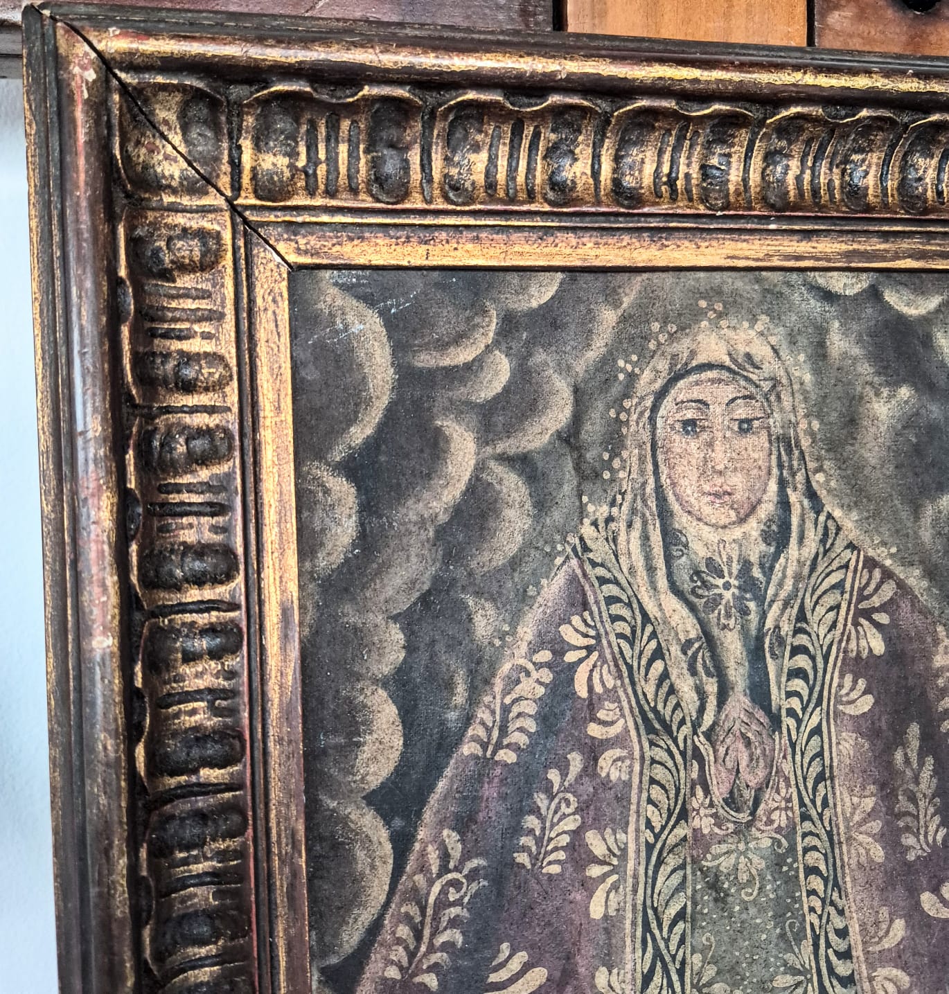  Quadro com pintura,  óleo sobre tela,  sacra antiga de Nossa Senhora, de Escola Cusquenha, caracterizada por traços coloniais, mantos ricamente ornamentados.