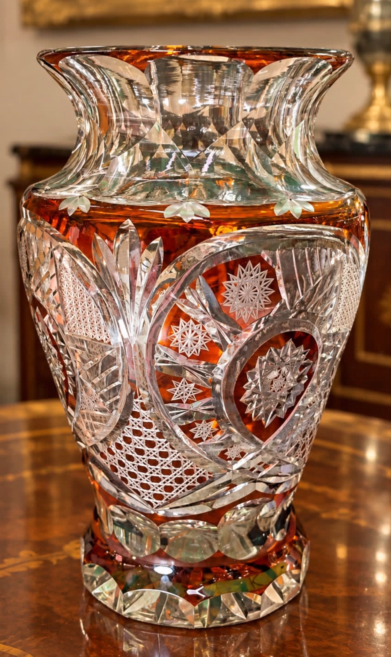 Deslumbrante Vaso em Cristal Francês, com sofisticada tonalidade âmbar e exuberante lapidação artesanal, revelando delicados desenhos geométricos e florais.