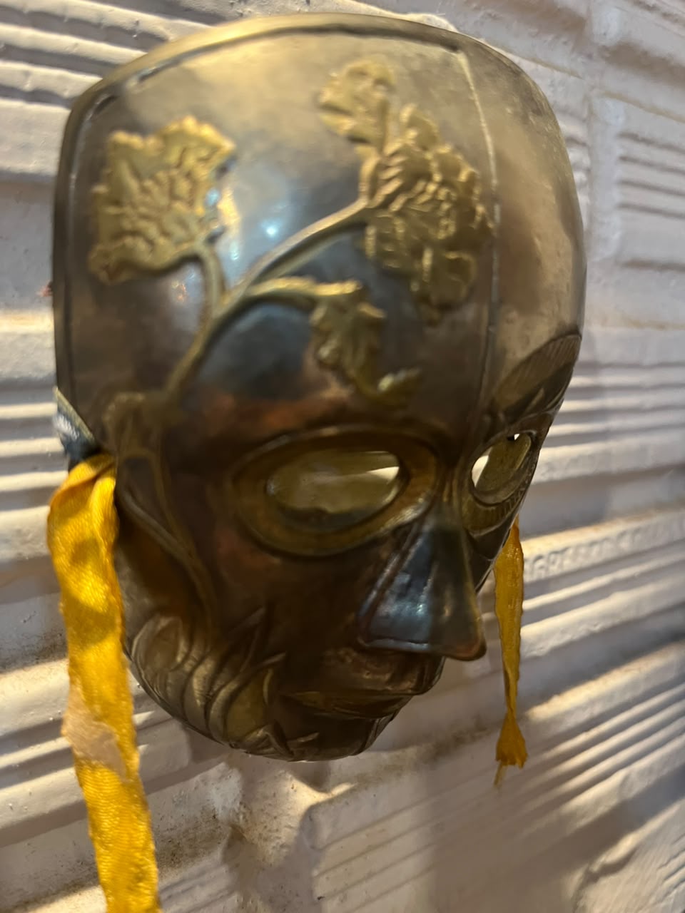 Máscara decorativa em metal com relevos figurativos — 11,5 × 9 cm