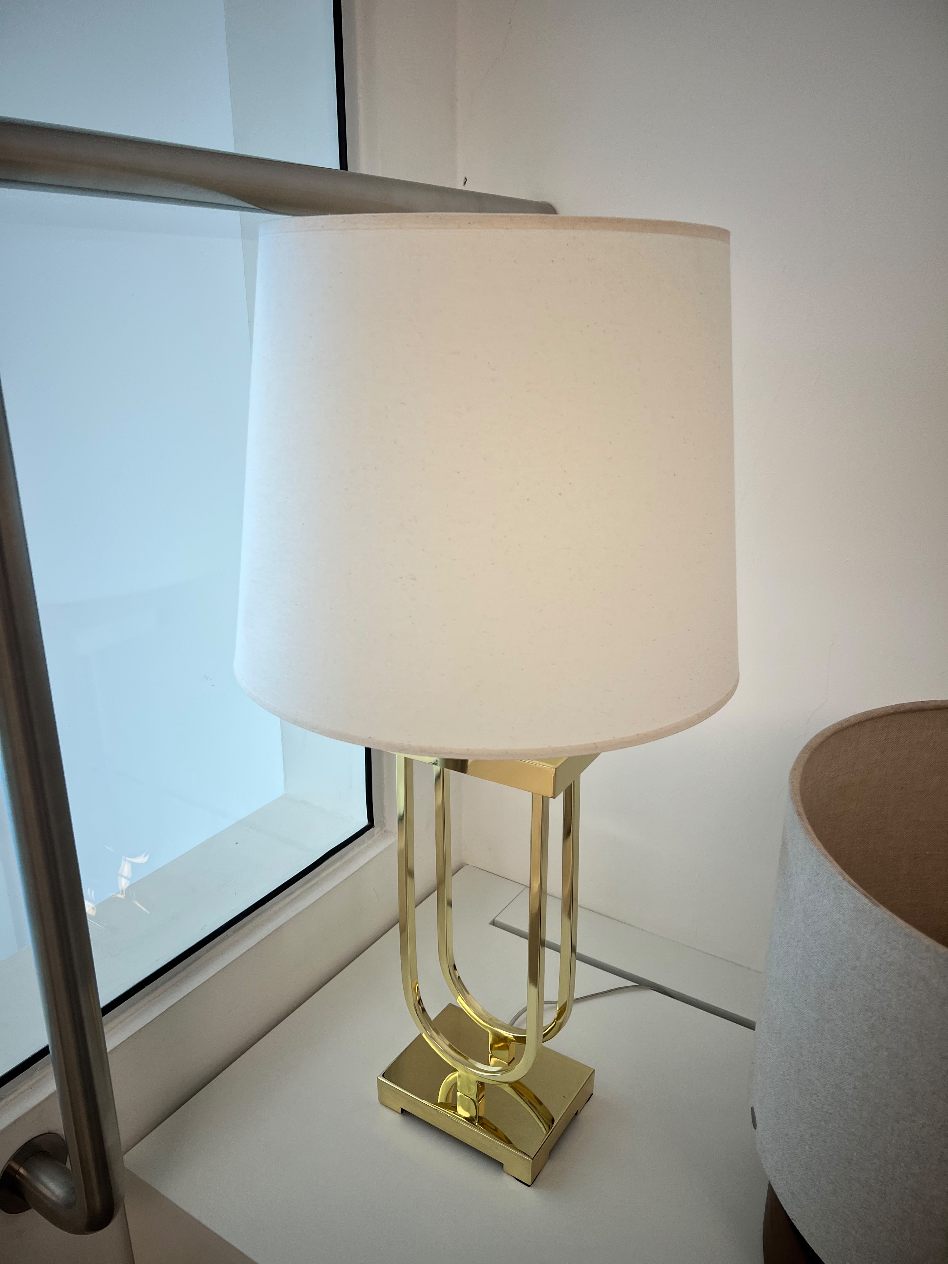 ABAJUR BELA ILUMINAÇÃO, COM CÚPULA EM TECIDO CLARO E BASE DOURADA