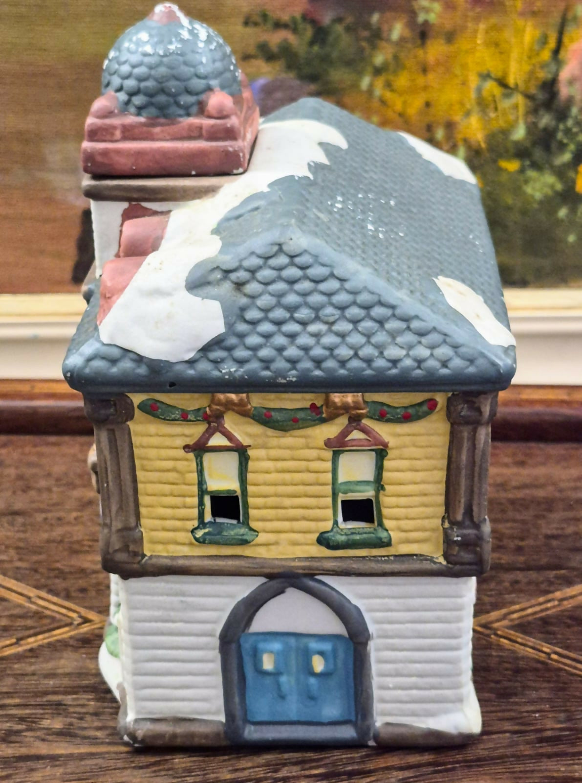 Casinha luminária representando estação de trem vintage, feita em biscuit, com portas, janelas e relógio frontal vazados para iluminação interna.