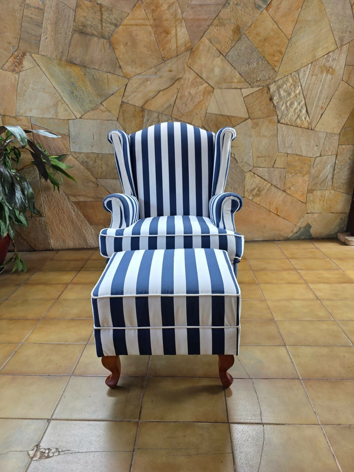 Poltrona bergere estofada e forrada com tecido acquablock listrado branco e azul.