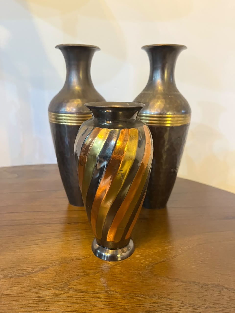 Trio de vasos decorativos em metal com acabamentos contrastantes