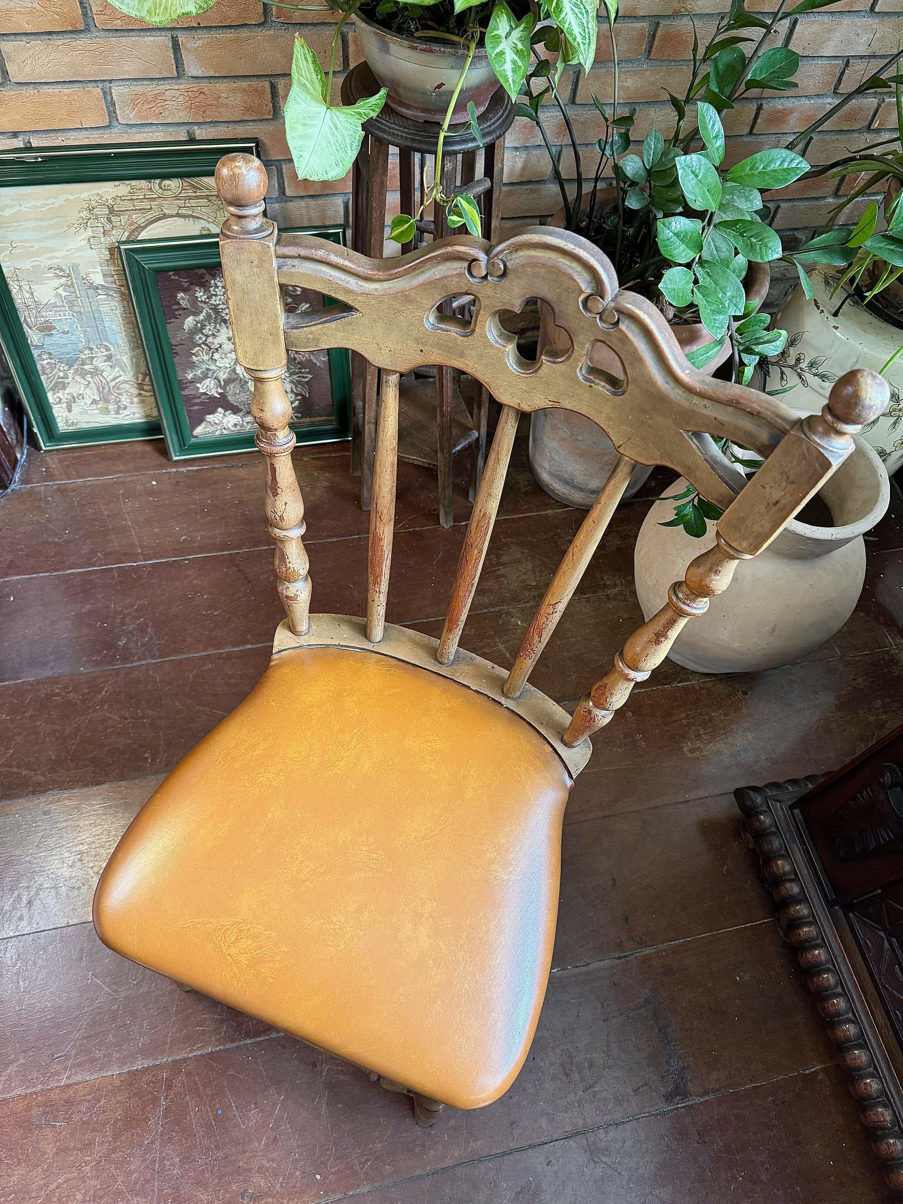 Antiga cadeira esculpida e madeira maciça e assento em couro