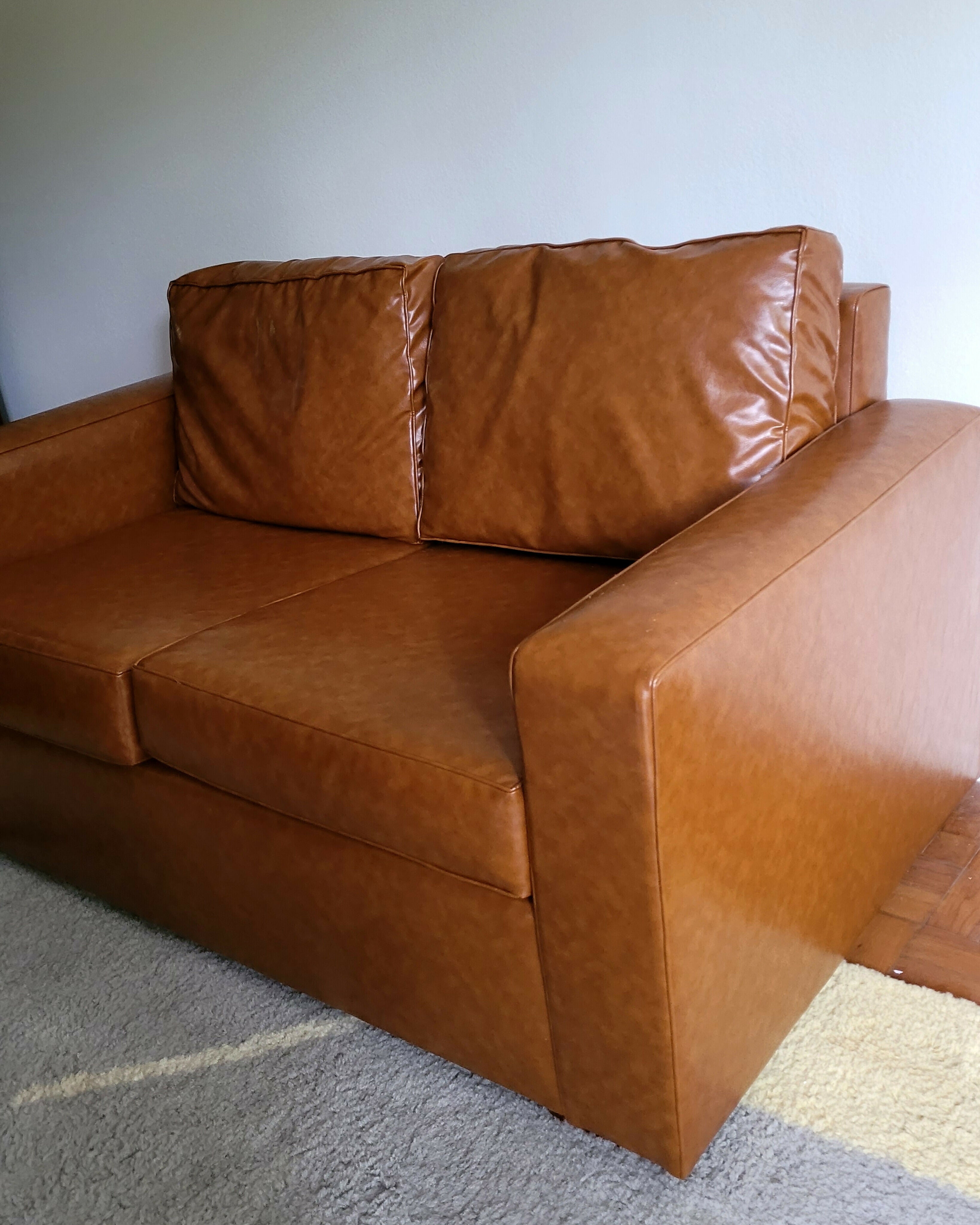 Sofá recém restaurado com estofado em couro ecológico caramelo
