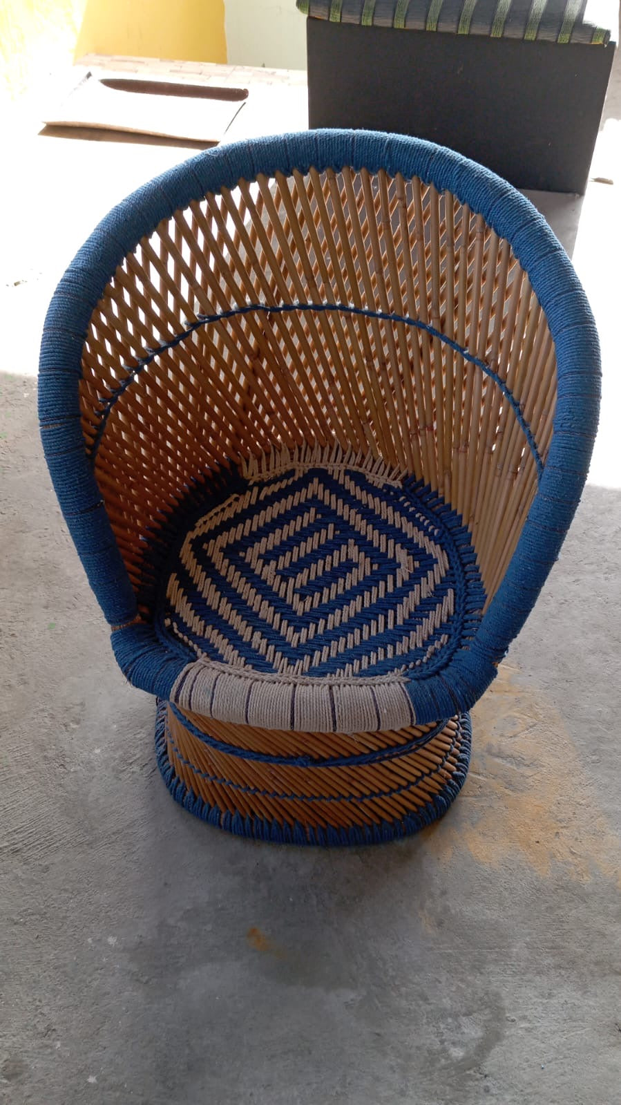 Cadeira arredondada de bambu com tecido crochê azul 