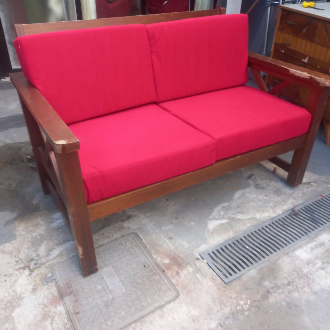 Sofá de madeira com estofado vermelho