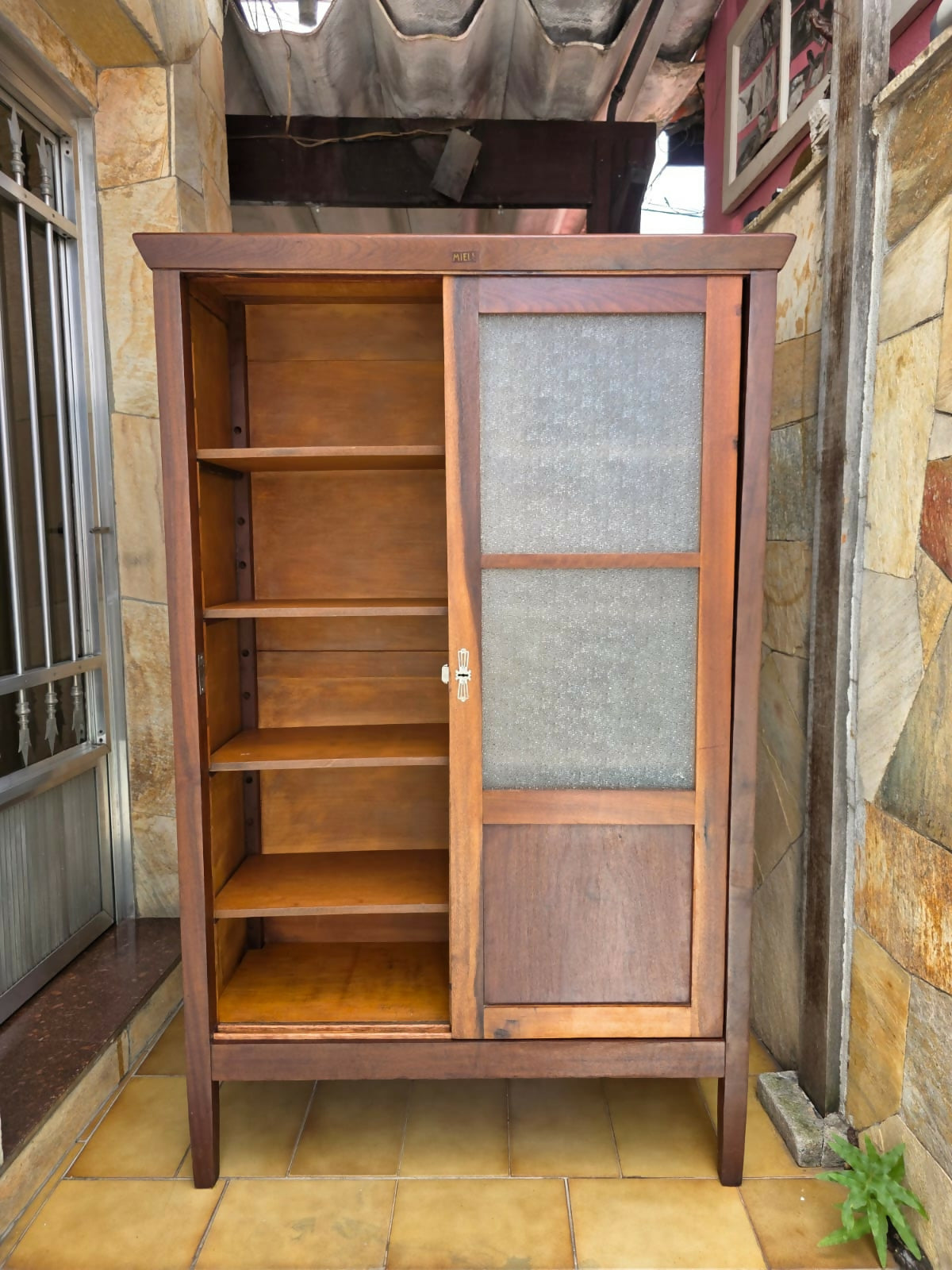 Armário / Livreiro Miele portas de correr, década de 60, possui 4 tábuas, selos da época, chave e fechadura.