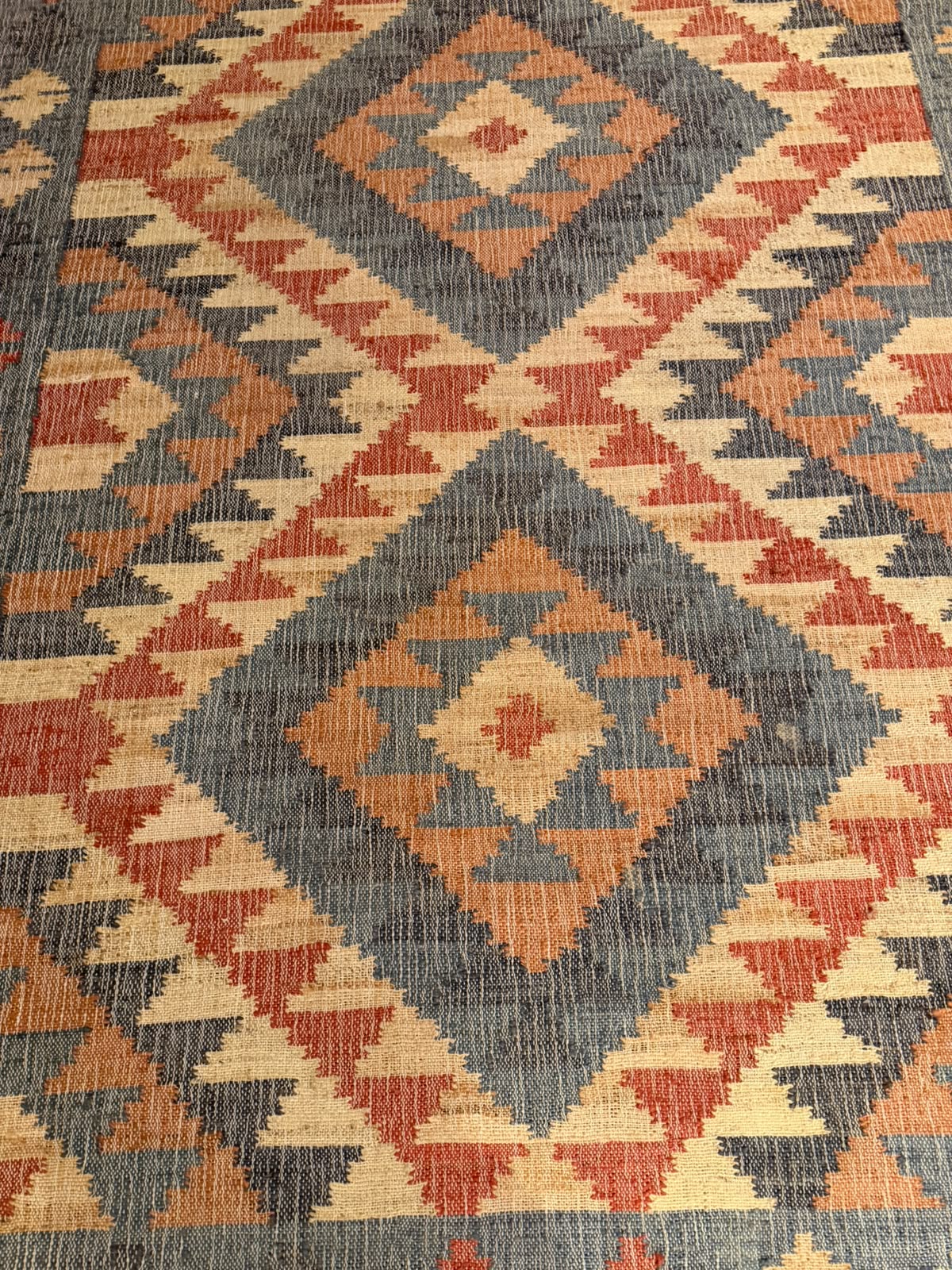 Tapete Kilim com estampa geométrica de tons de azul, rosado, bege e creme