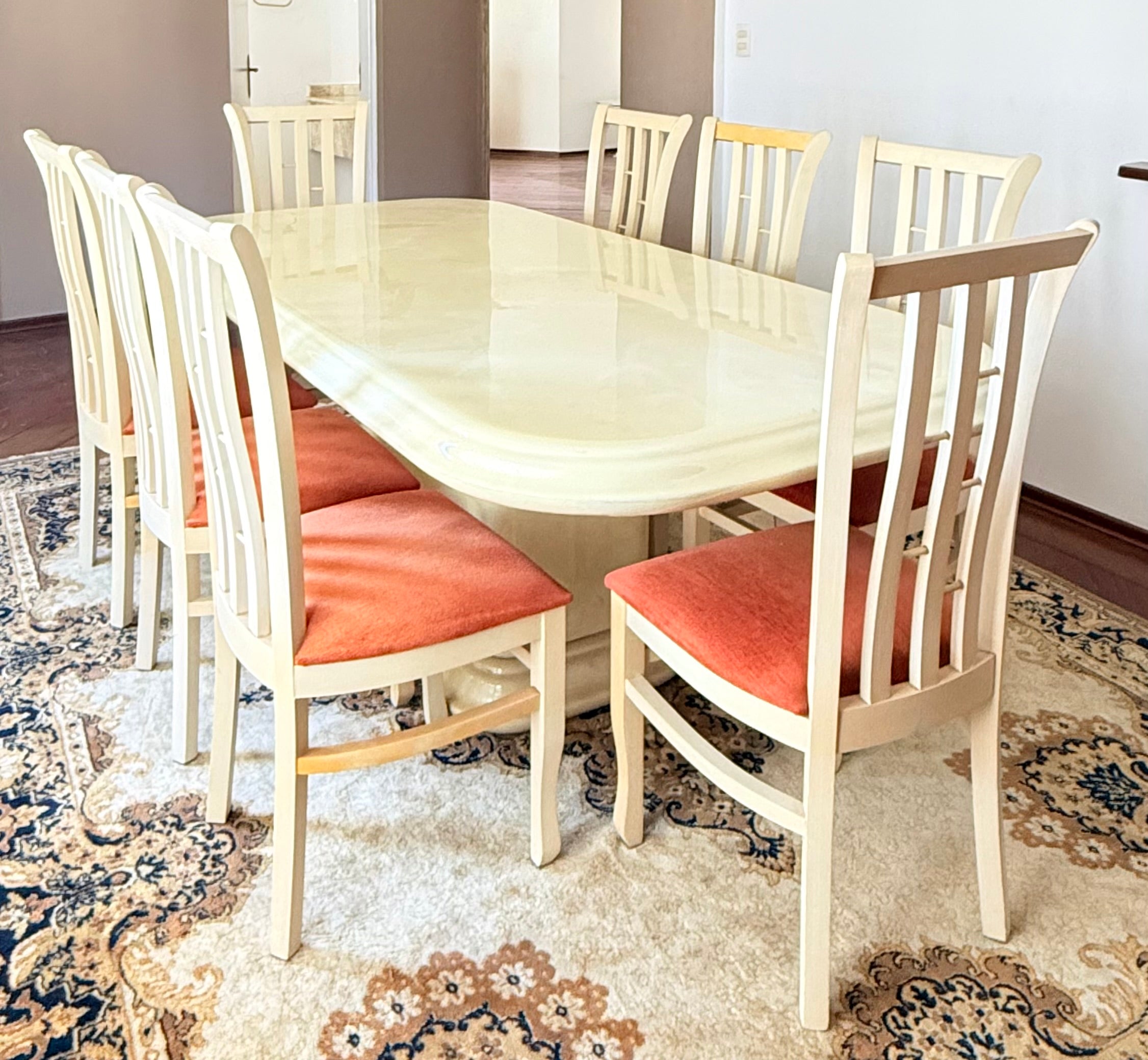 Mesa de jantar Retangular resinada em branco com 8 cadeiras de estofado alaranjado 