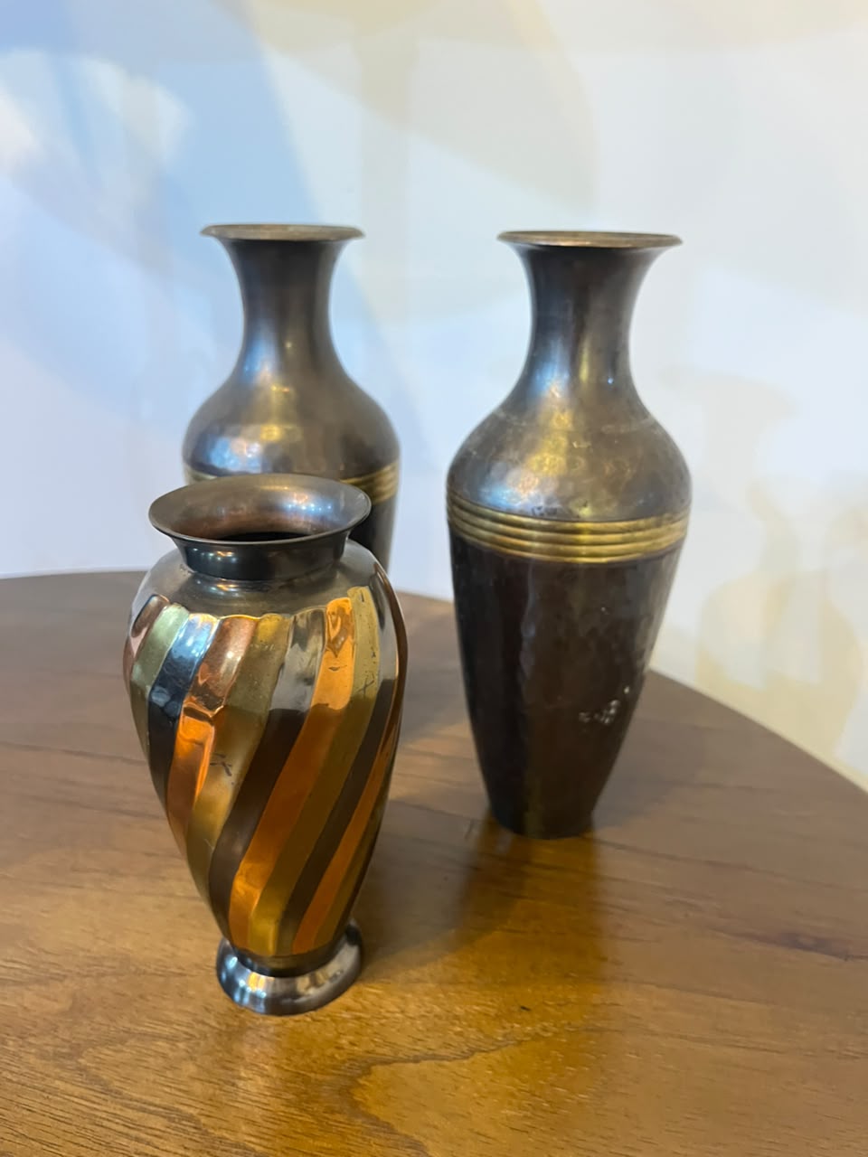 Trio de vasos decorativos em metal com acabamentos contrastantes