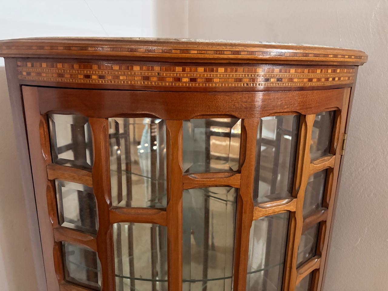 Pequena cristaleira de canto com vidros bisotados e acabamento em fina marchetaria