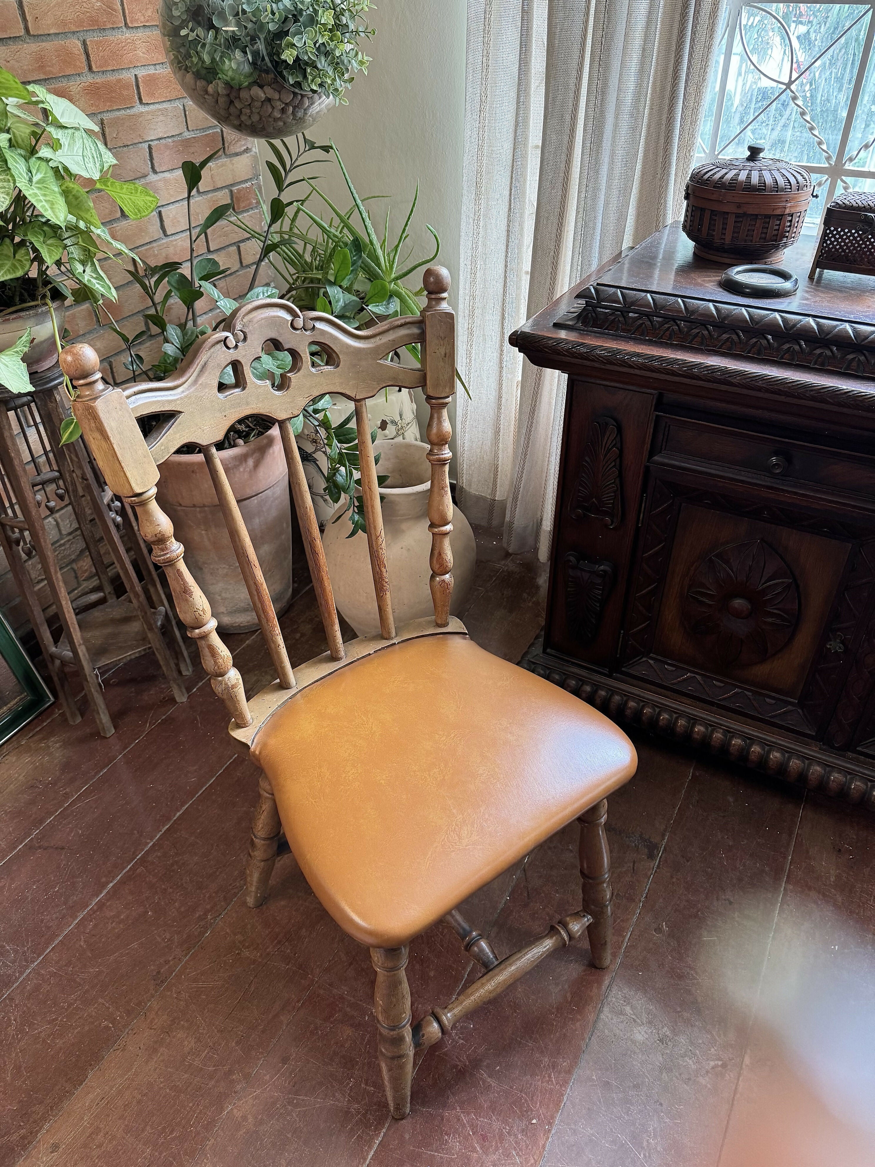 Antiga cadeira esculpida e madeira maciça e assento em couro