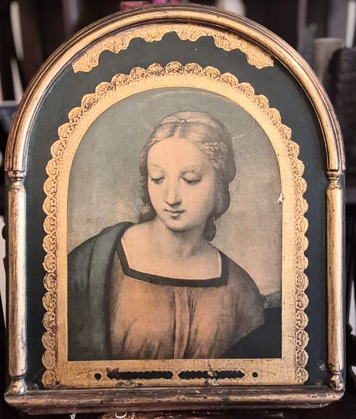 Quadro sacro retrata o rosto da Virgem Maria inspirado na famosa obra renascentista Madonna do Pintassilgo do pintor italiano Rafael Sanzio.