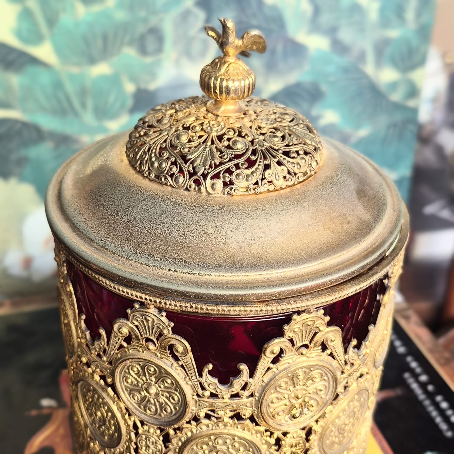 Potiche vintage com parte interna em vidro cranberry e parte externa em metal trabalhado em filigrana e ornamentado com medalhões, como antigas rendas metálicas.