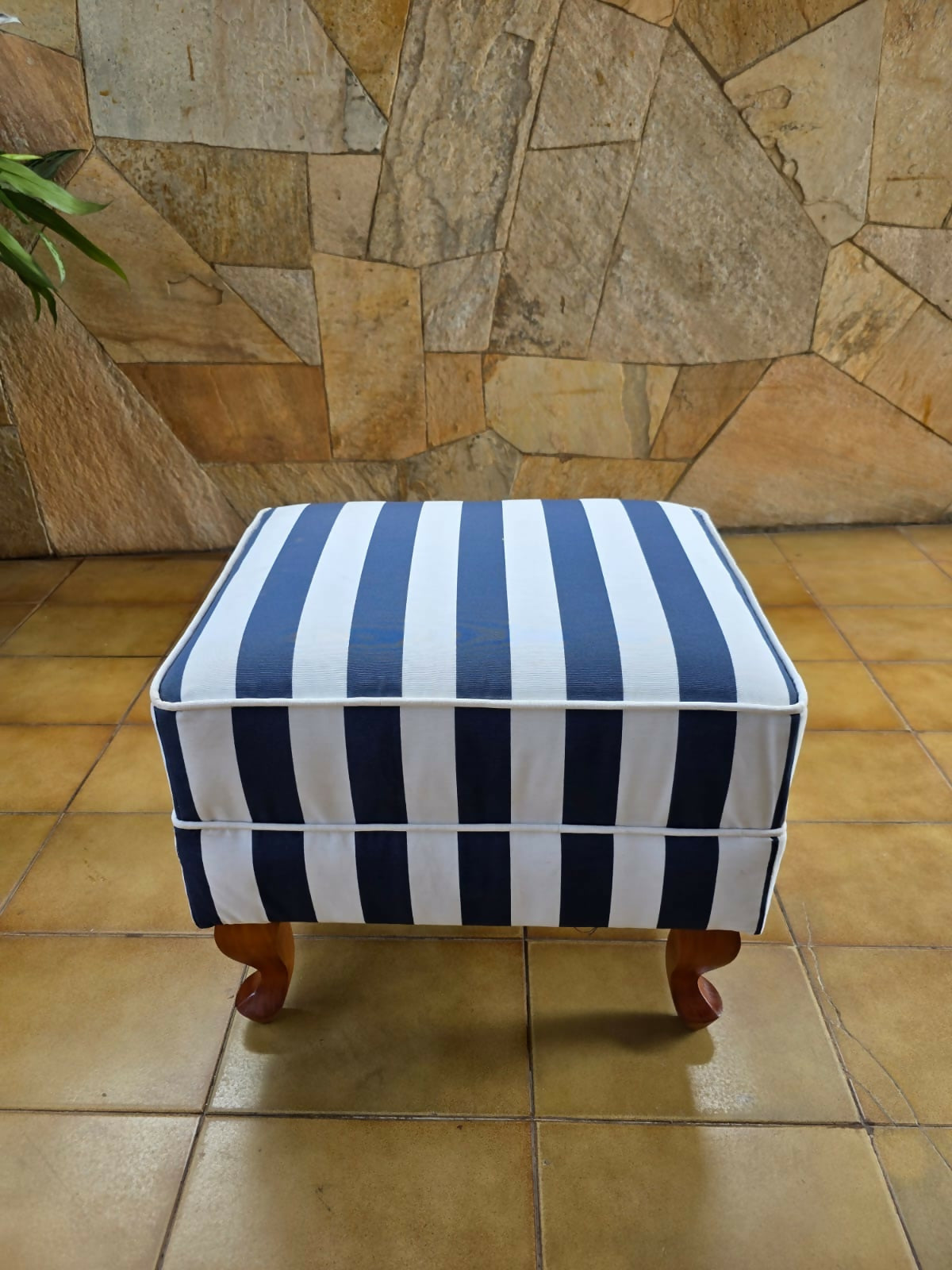 Poltrona bergere estofada e forrada com tecido acquablock listrado branco e azul.