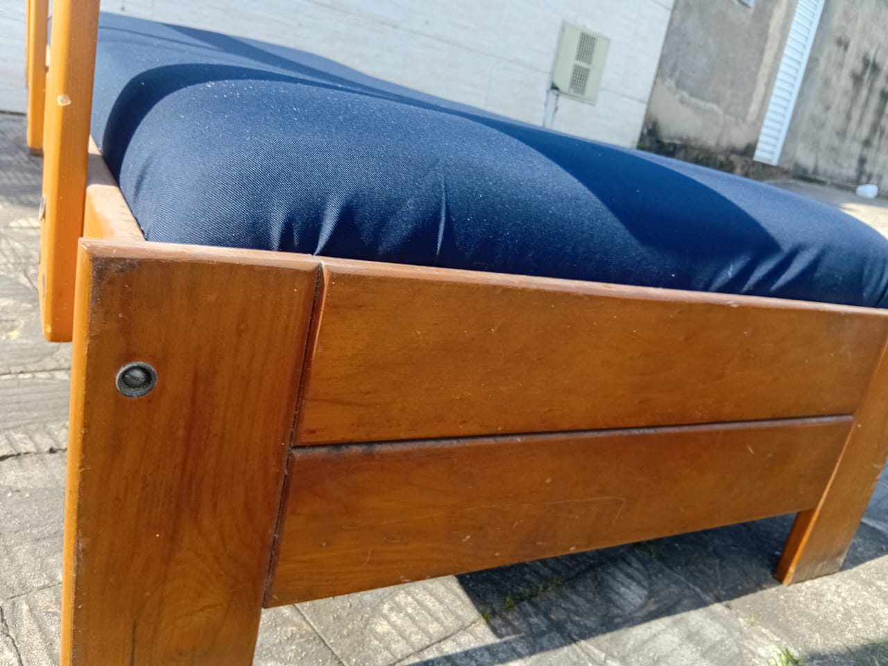 Sofá de madeira com estofado azul 