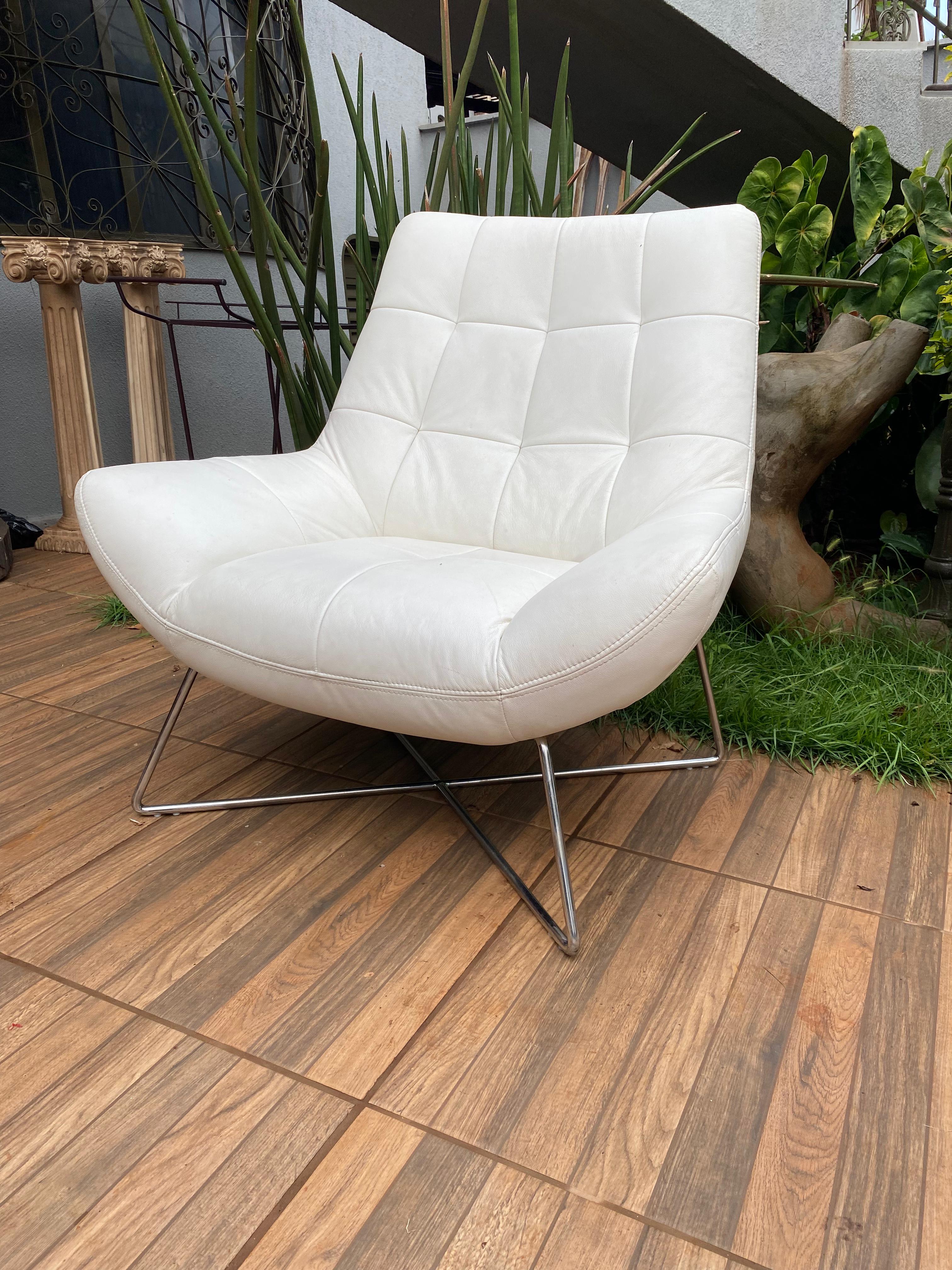 Poltrona Confortável com estofamento em couro branco e pés em metal 