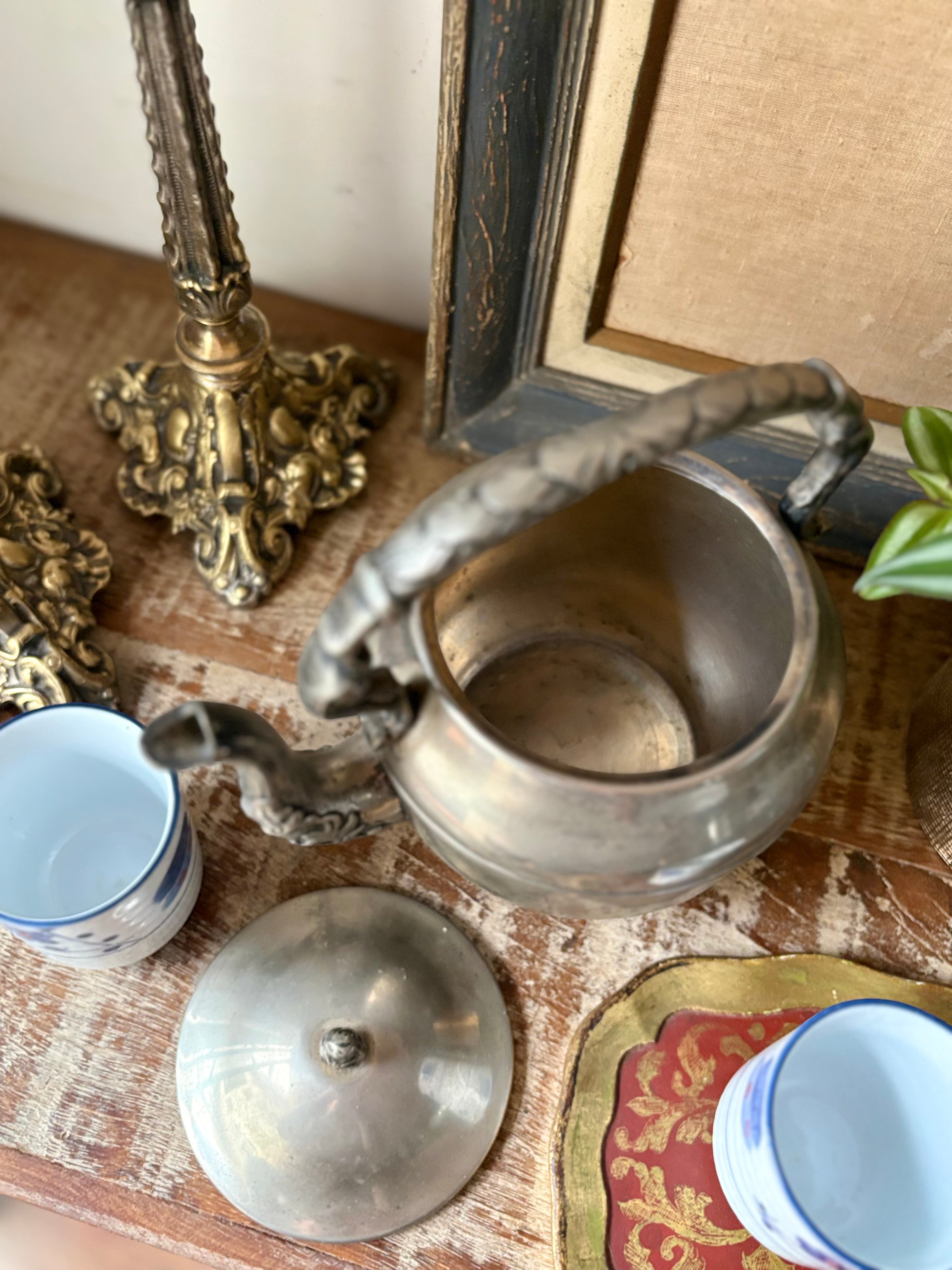 Bule em metal prateado com detalhes trabalhados