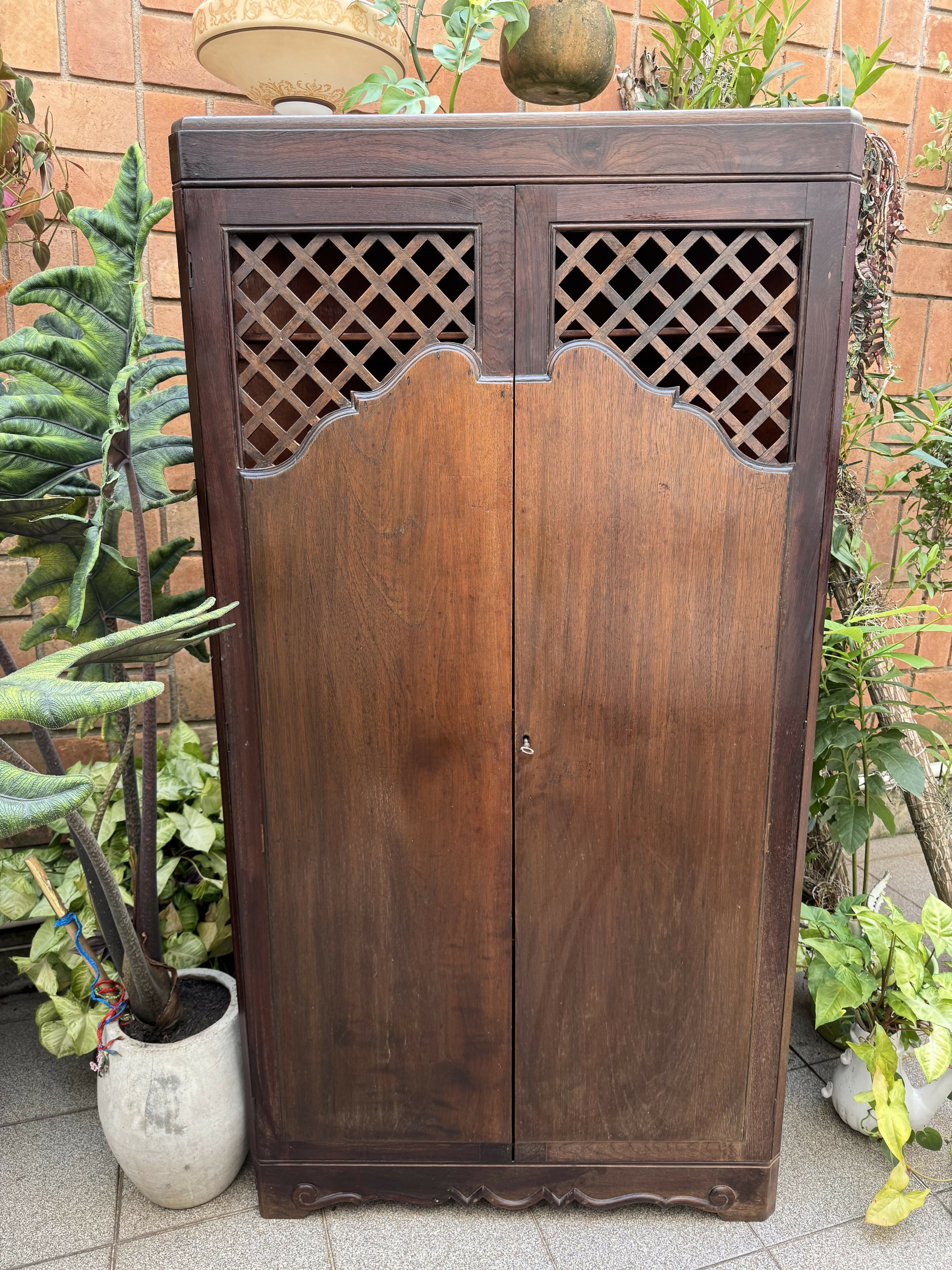 Antigo armário de canto esculpido e com treliças