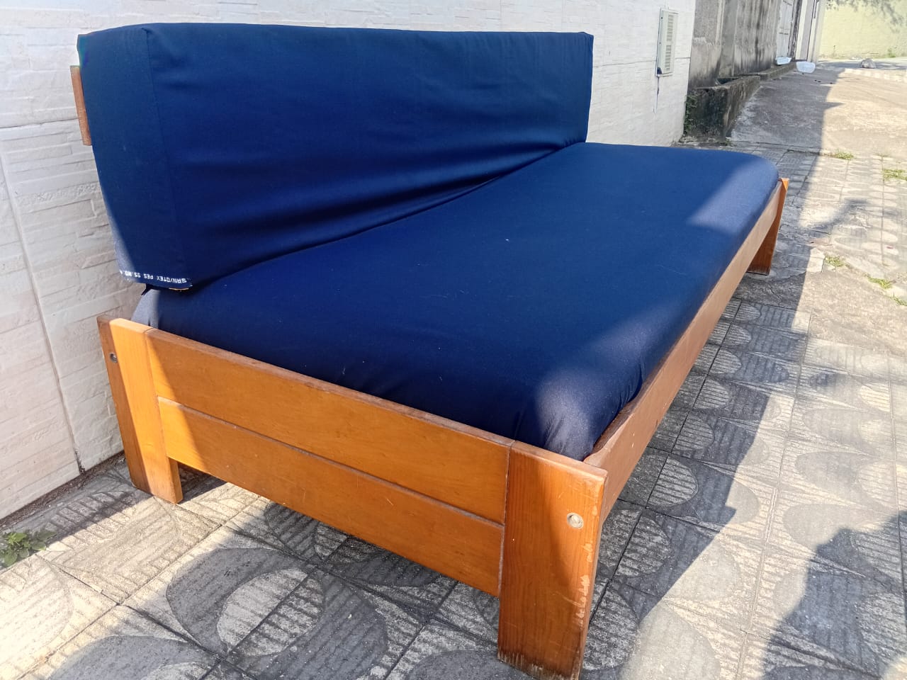 Sofá de madeira com estofado azul 