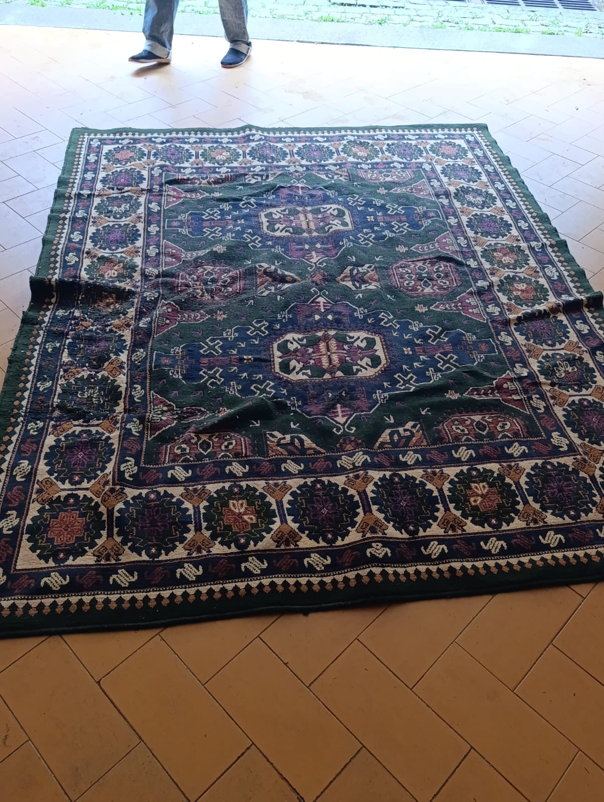 Tapete oriental com padrão geométrico em tons verde, azul e vinho 