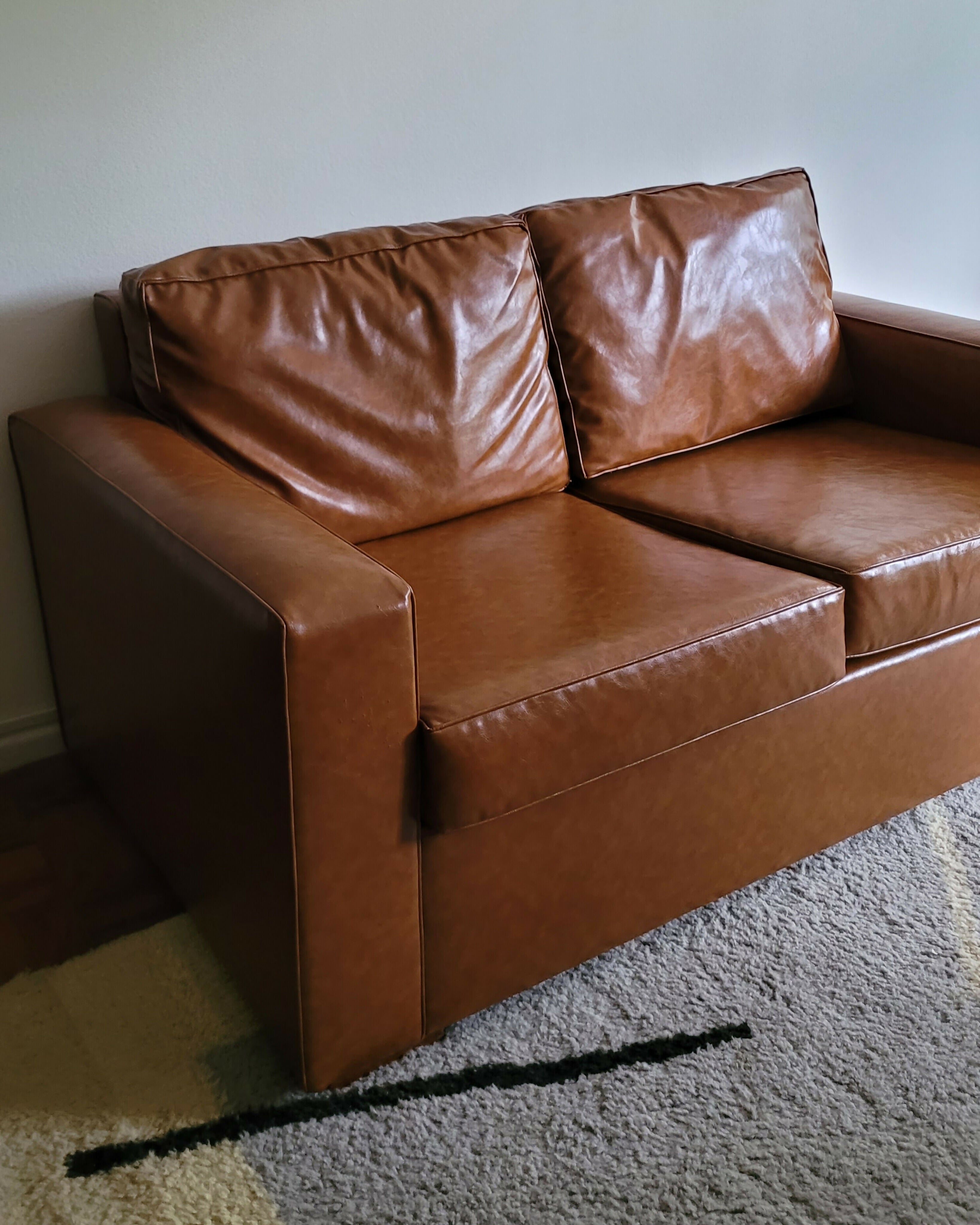 Sofá recém restaurado com estofado em couro ecológico caramelo