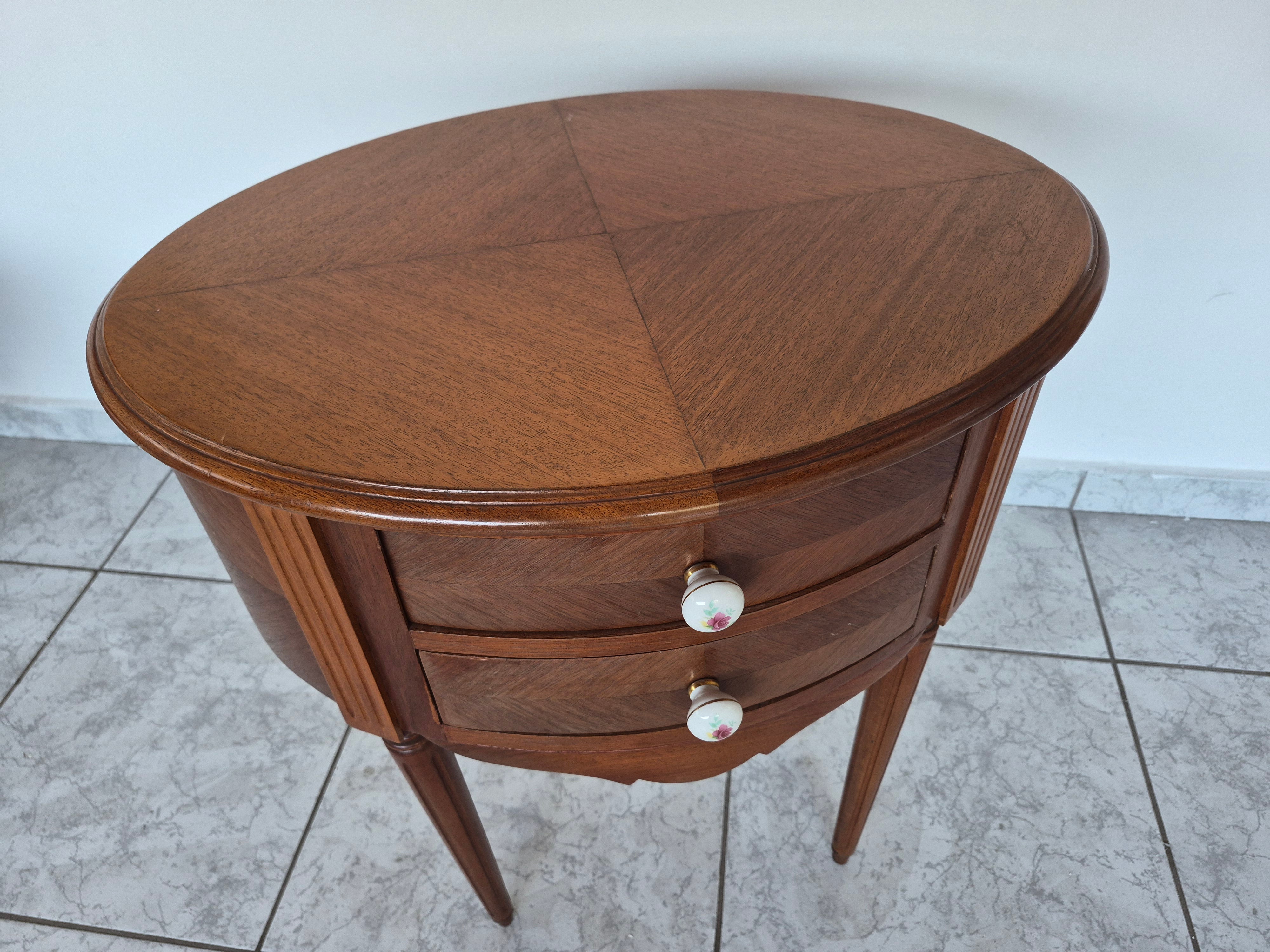 Mesa auxiliar oval em madeira nobre clara com duas gavetas 