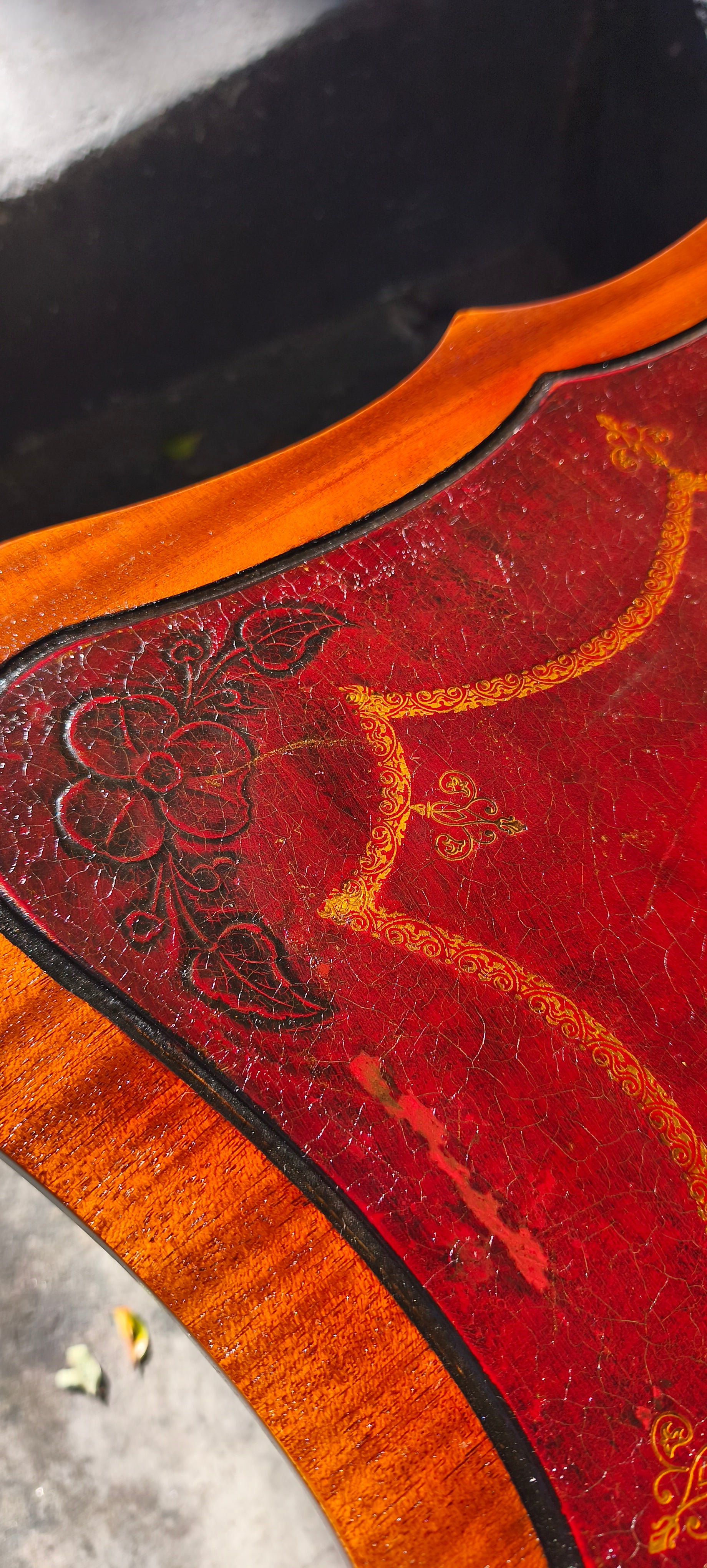 Mesa auxiliar quadrada com tampo em couro vermelho com detalhes florais e pernas torneadas