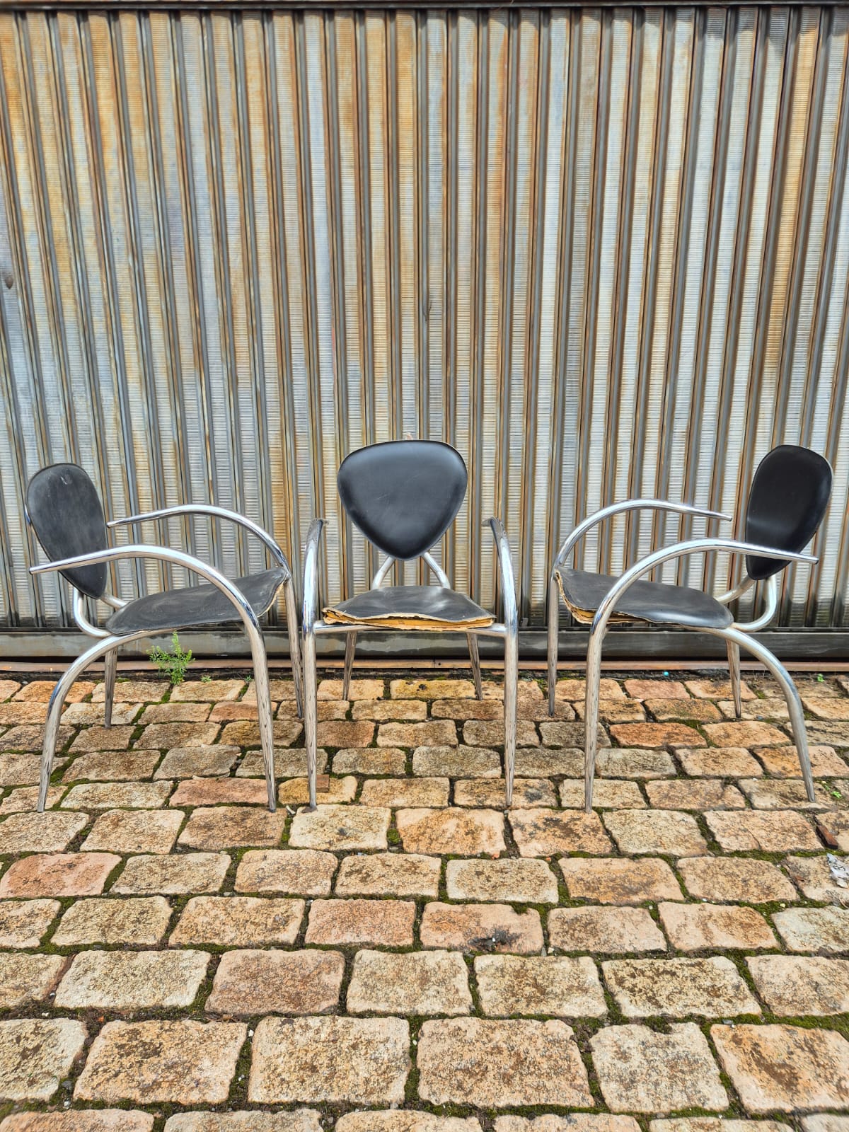 Cadeiras de Design Italiano com linhas curvas em metal tubular e assento preto 