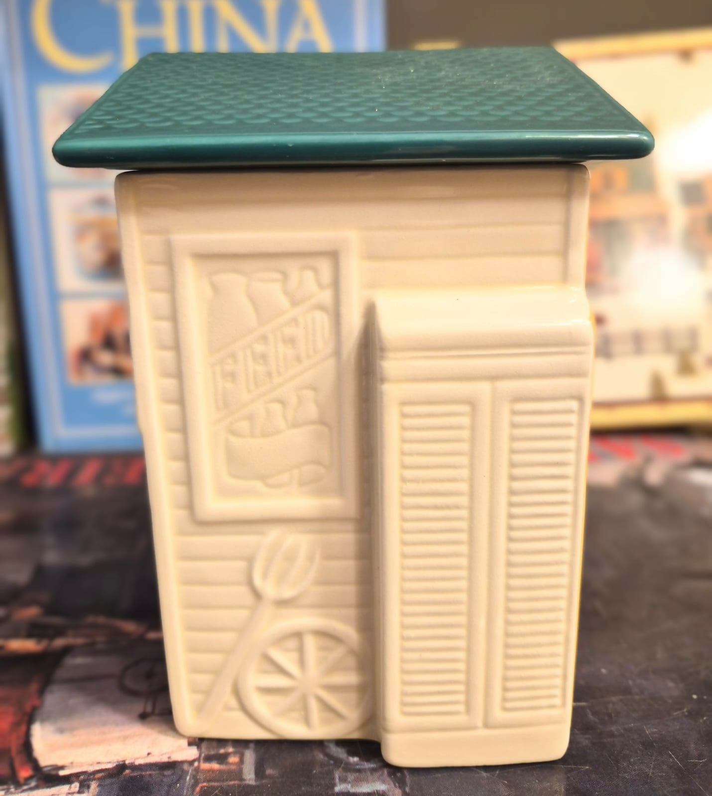 Biscoiteira de cerâmica em formato de casinha " General Store", parte da coleção da Avon Townhouse.