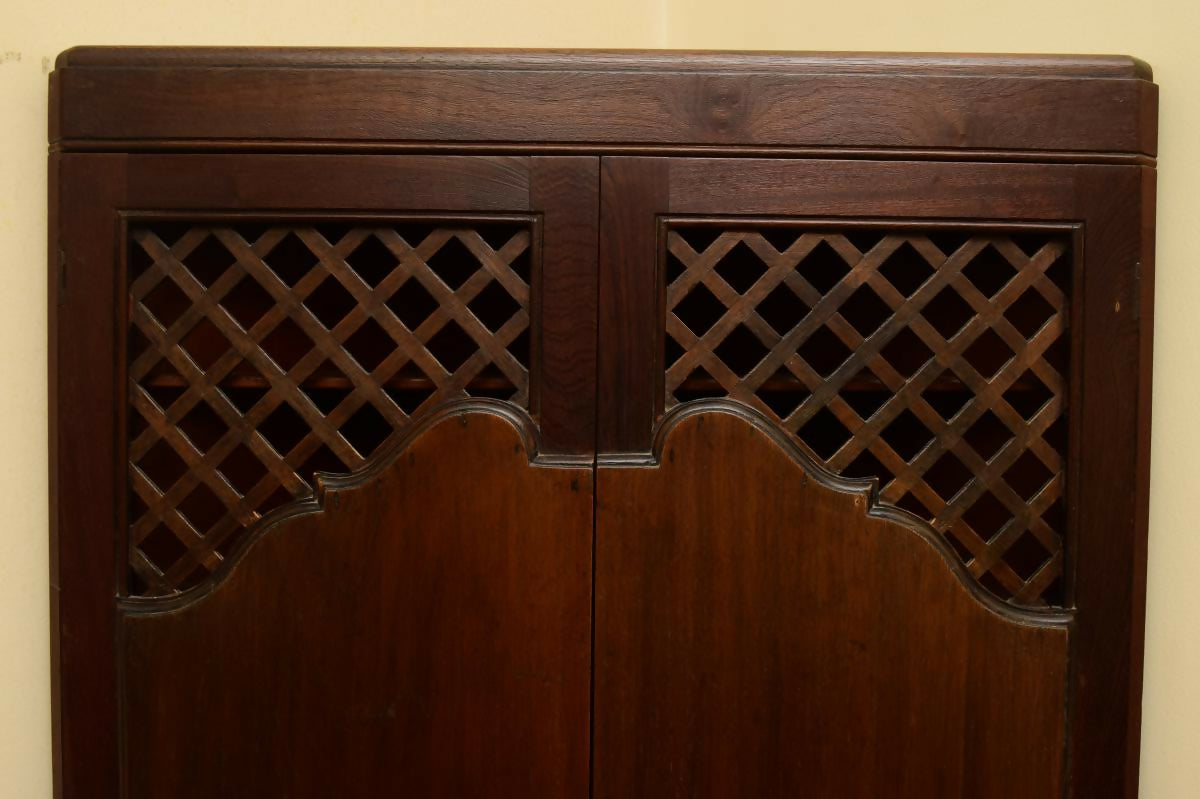 Antigo armário de canto esculpido e com treliças