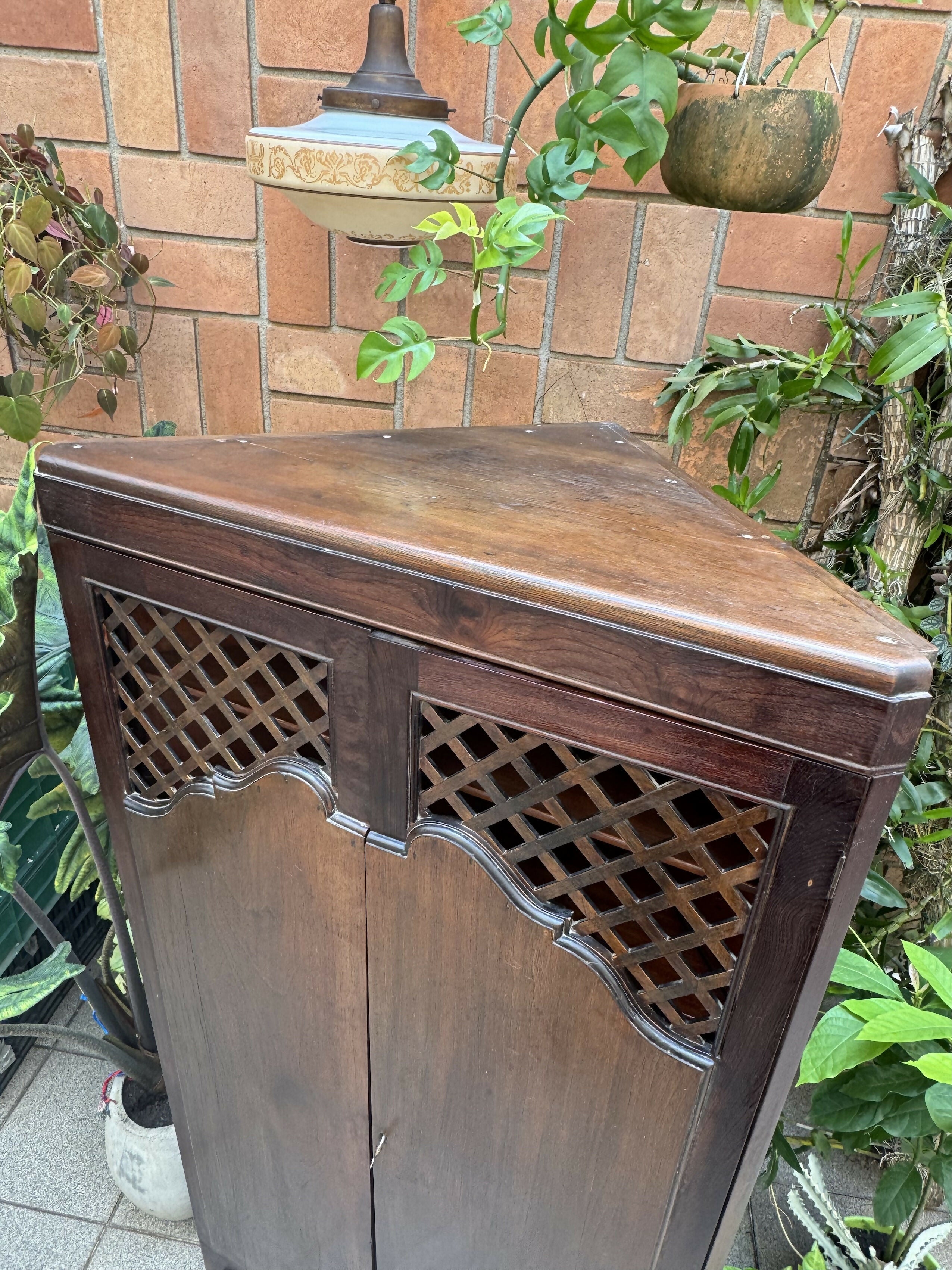 Antigo armário de canto esculpido e com treliças