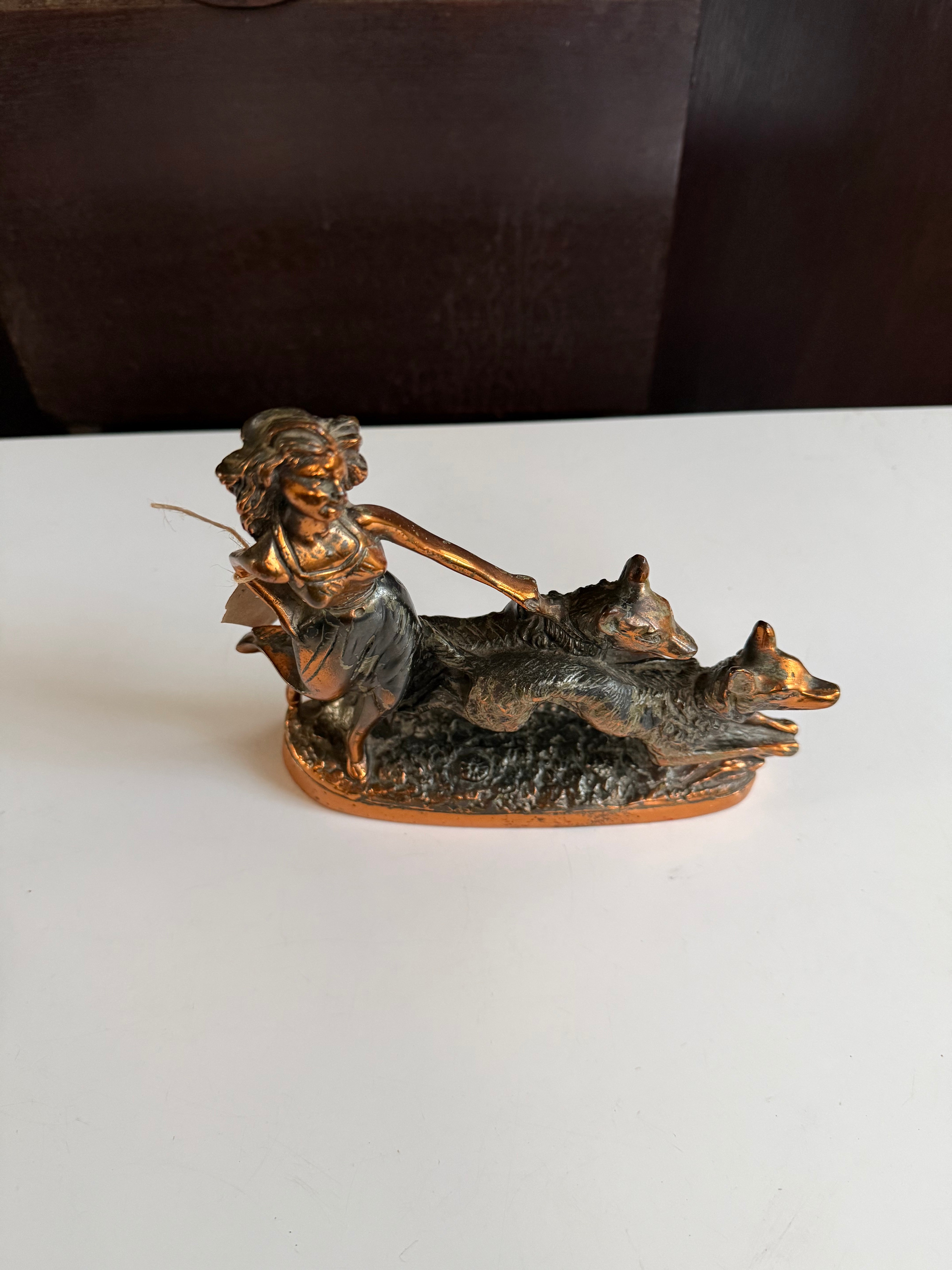 Escultura decorativa em petit bronze representando uma mulher acompanhada por dois cachorros 