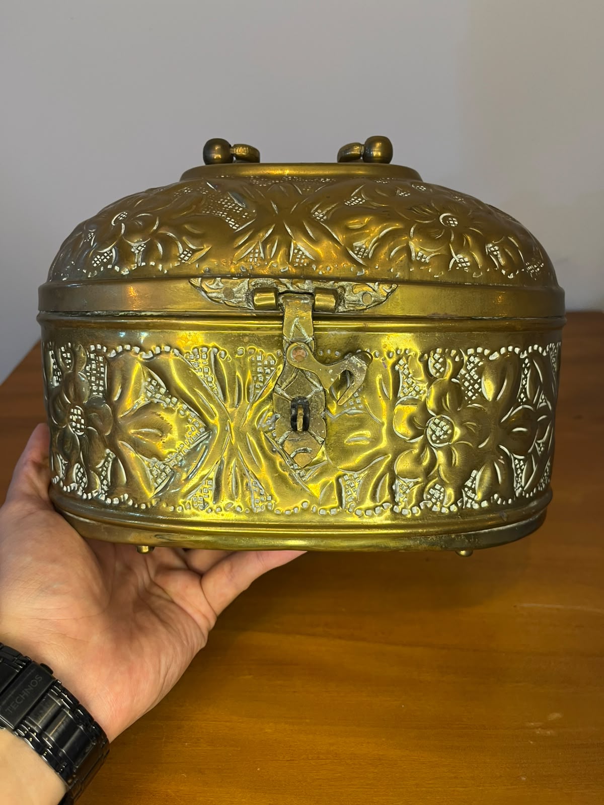 Caixa decorativa oval em metal dourado repuxado – motivos florais | 23 × 14 × 17 cm