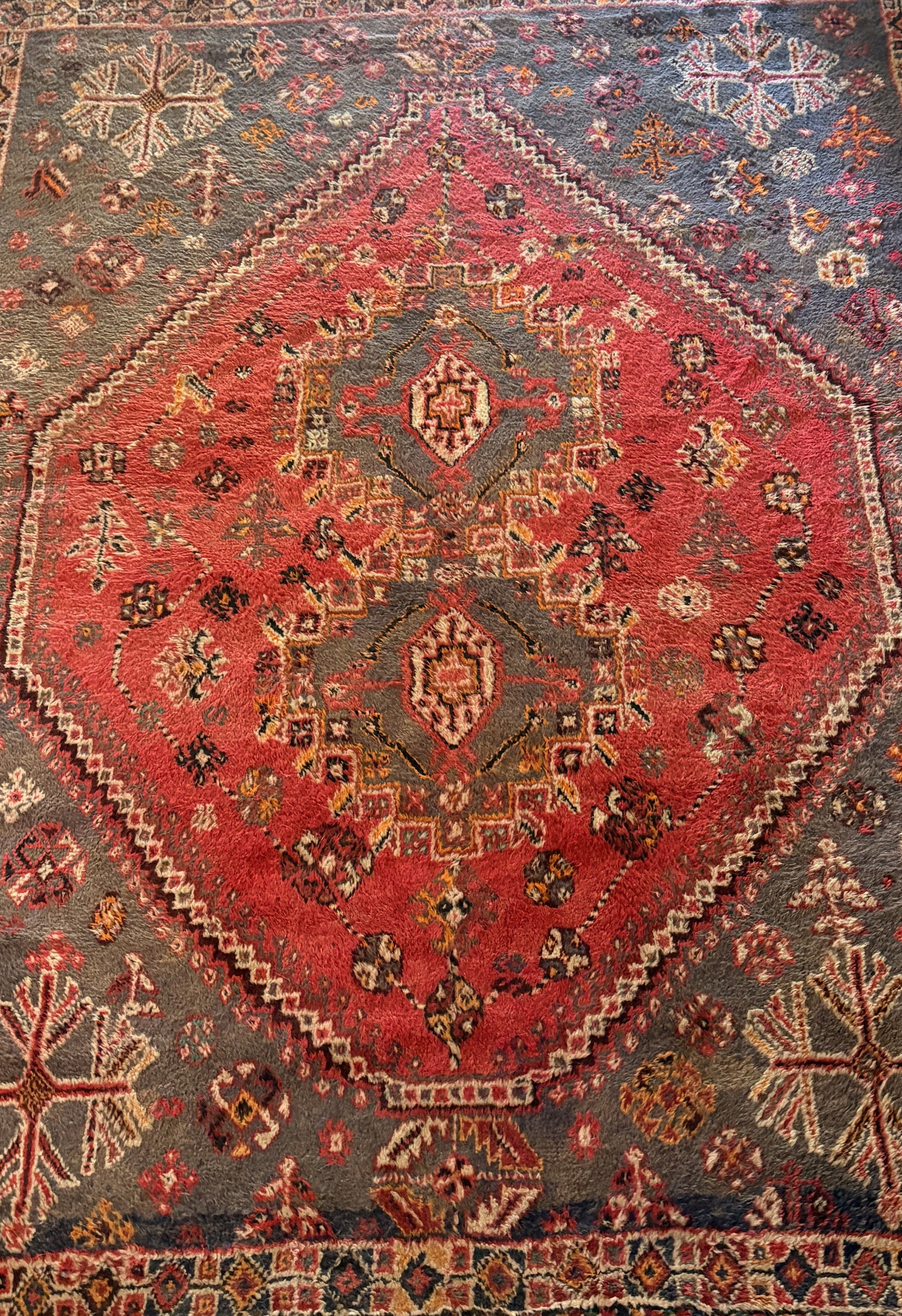 Tapete persa com medalhão central geométrico em vermelho intenso